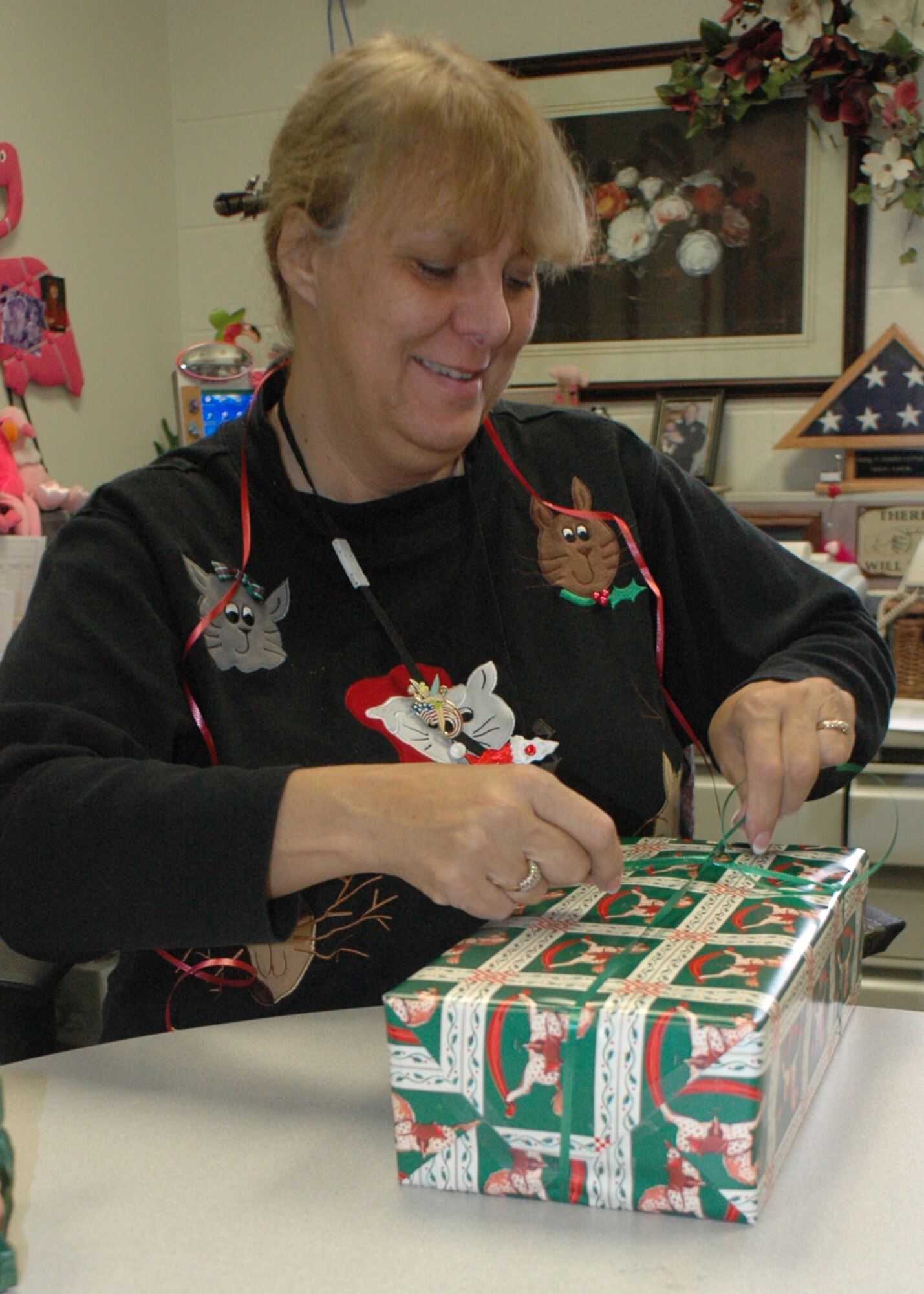 Carol Little, 917th Wing Financial Management budget analyst, wraps a present to be given to a needy child as part of the Air Force's Santas in Blues program. (U.S. Air Force photo/Tech. Sgt. Sherri Savant)