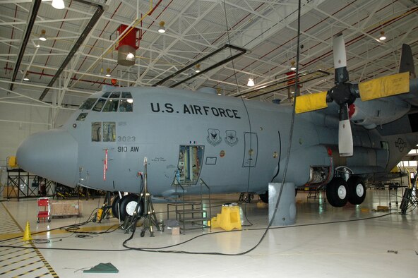 YOUNGSTOWN AIR RESERVE STATION, Ohio—Four hydraulic lifts raise an 86,000 pound C-130 aircraft entirely off the floor of an aircraft maintenance hangar here Dec. 19, 2006.  The aircraft was raised for the purpose of changing the nose landing gear strut as part of an isochronal inspection.  U.S. Air Force photo/Master Sgt. Bryan Ripple.  