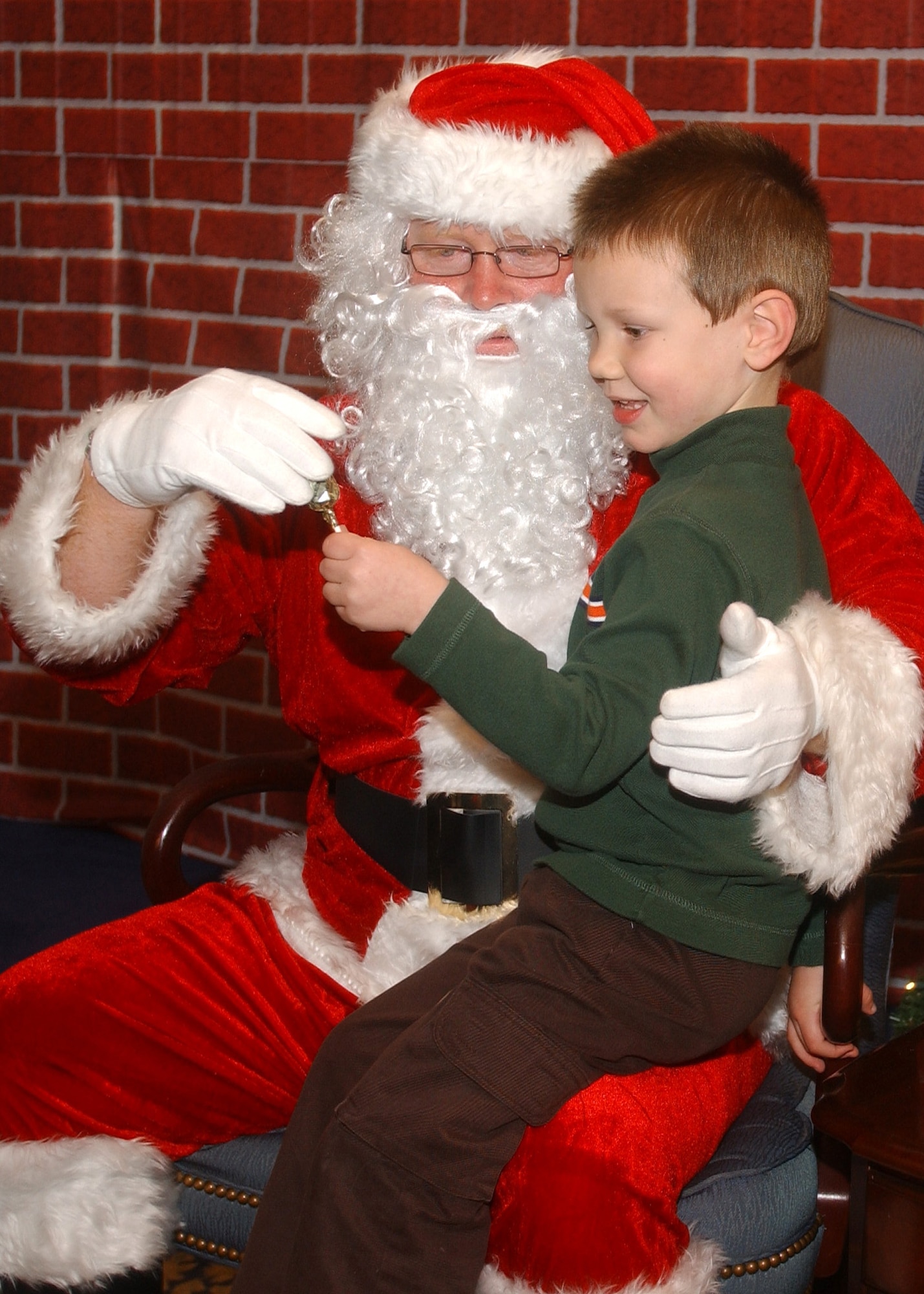 Alex Ammons, dependent of Master Sgt. Charles Ammons of the Mission Support Squadron, gets a treat from Santa after giving him his wish list at the Breakfast with Santa event December 16, 2006, at Vandenberg's Pacific Coast Club.  Alex was one of more than 1500 children and their parents in attendance.  The event is sponsored by the 30th Services Division annually and is open to all Vandenberg families.  (U.S. Air Force photo by Airman 1st Class Nicole Roberts)