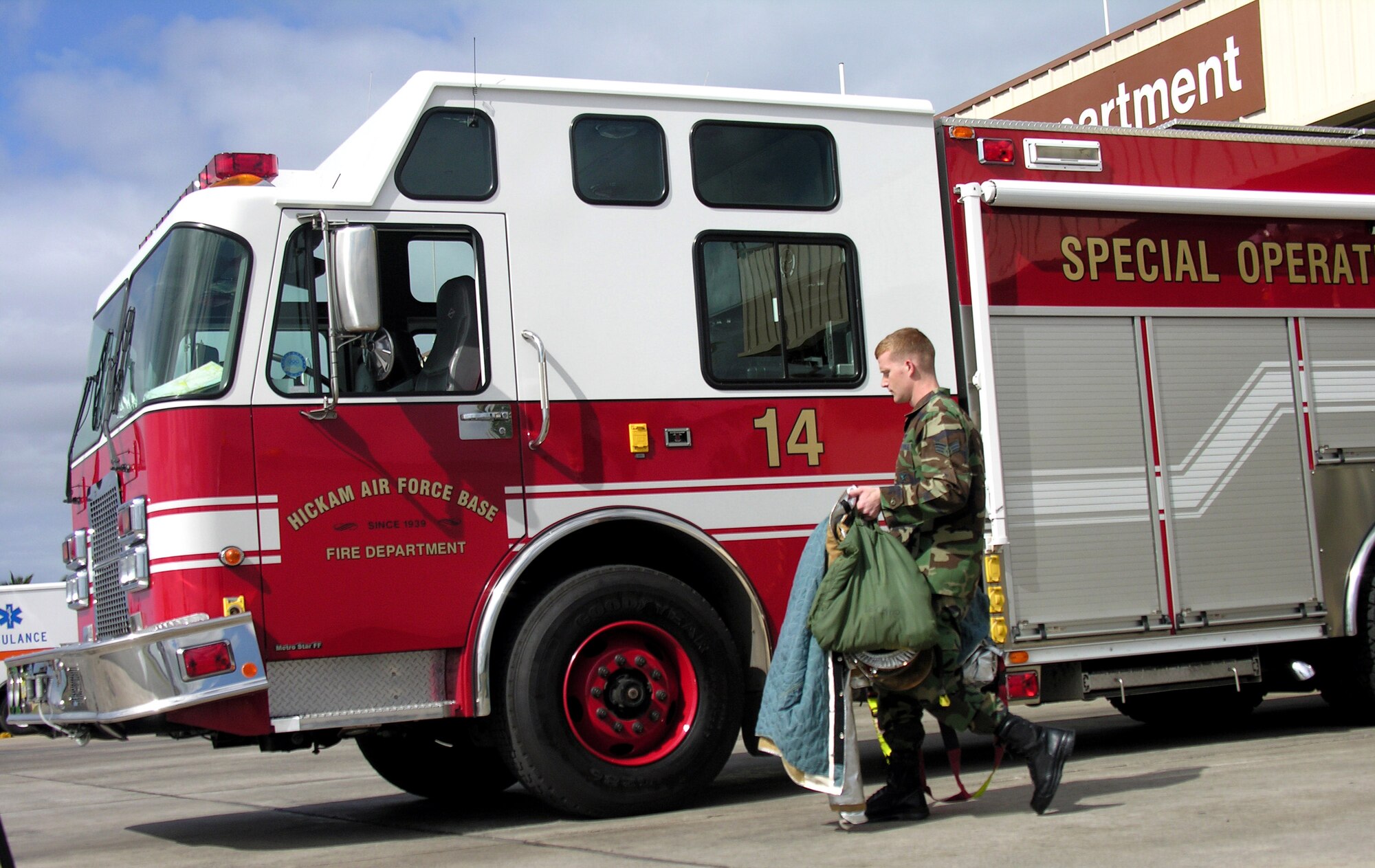 Senior Airman Alan Leckie drops his gear by a fire truck at Hickam Air Force Base, Hawaii.  He is a firefighter assigned to the 15th Civil Engineer Squadron. (U.S. Air Force photo/2nd Lt. Melanie McLean)