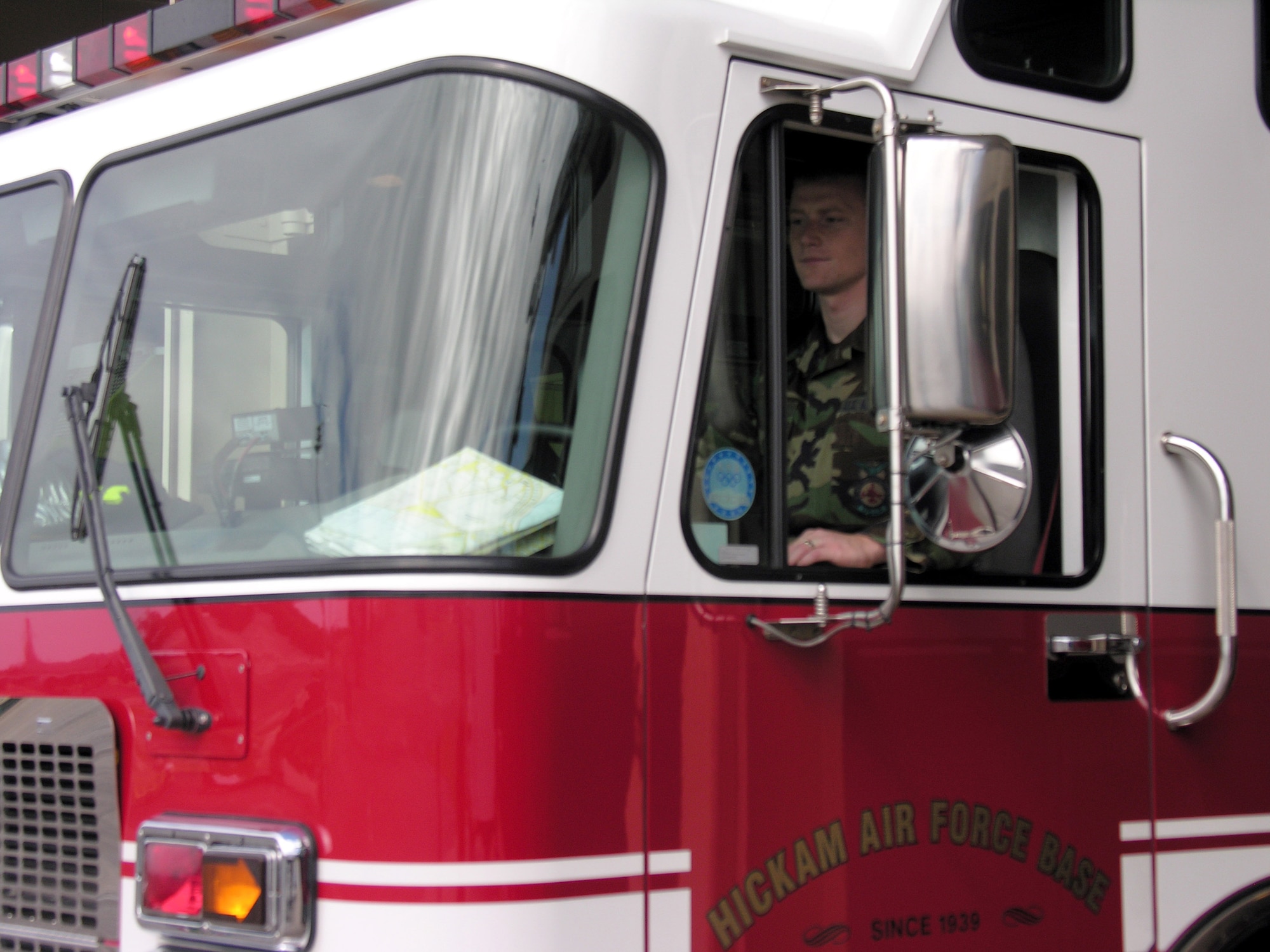 Senior Airman Alan Leckie drives a rescue truck out of the fire station at Hickam Air Force Base, Hawaii. Airman Leckie, assigned to the 15th Civil Engineer Squadron, will work Christmas Day. (U.S. Air Force photo/2nd Lt. Melanie McLean)