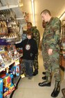 MINOT AIR FORCE BASE, N.D. -- Senior Airman Marcus Carter, Senior Airman Dewaun Bass, and Airman Jonathan Morrison, all with the 5th Security Forces Squadron, look at gifts with Josh Heath at K-Mart in Minot, ND, during the annual "Shop with a Cop" program Dec. 17, 2006. Seventy-seven children received a $100 gift card during this year’s event which helps disadvantaged children during the holiday season to buy presents of their choosing.  Each child is assigned a law enforcement officer to assist with their shopping, but because of the overwhelming outcome, many children were escorted by several adults, such as Heath. (U.S. Air Force photo by Airman 1st Class Christopher Boitz)