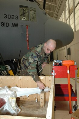 YOUNGSTOWN AIR RESERVE STATION, Ohio—Air Force Reserve Senior Airman Scott Rothenberg, an aircraft maintenance technician with the repair and reclamation shop at the 910th Maintenance Squadron unloads a nose landing gear strut here Dec. 19, 2006.  The strut was installed on aircraft 3023 as part of a time change compliance installation.  Airman Rothenberg is a resident of Mentor, Ohio.  U.S. Air Force photo/Master Sgt. Bryan Ripple.