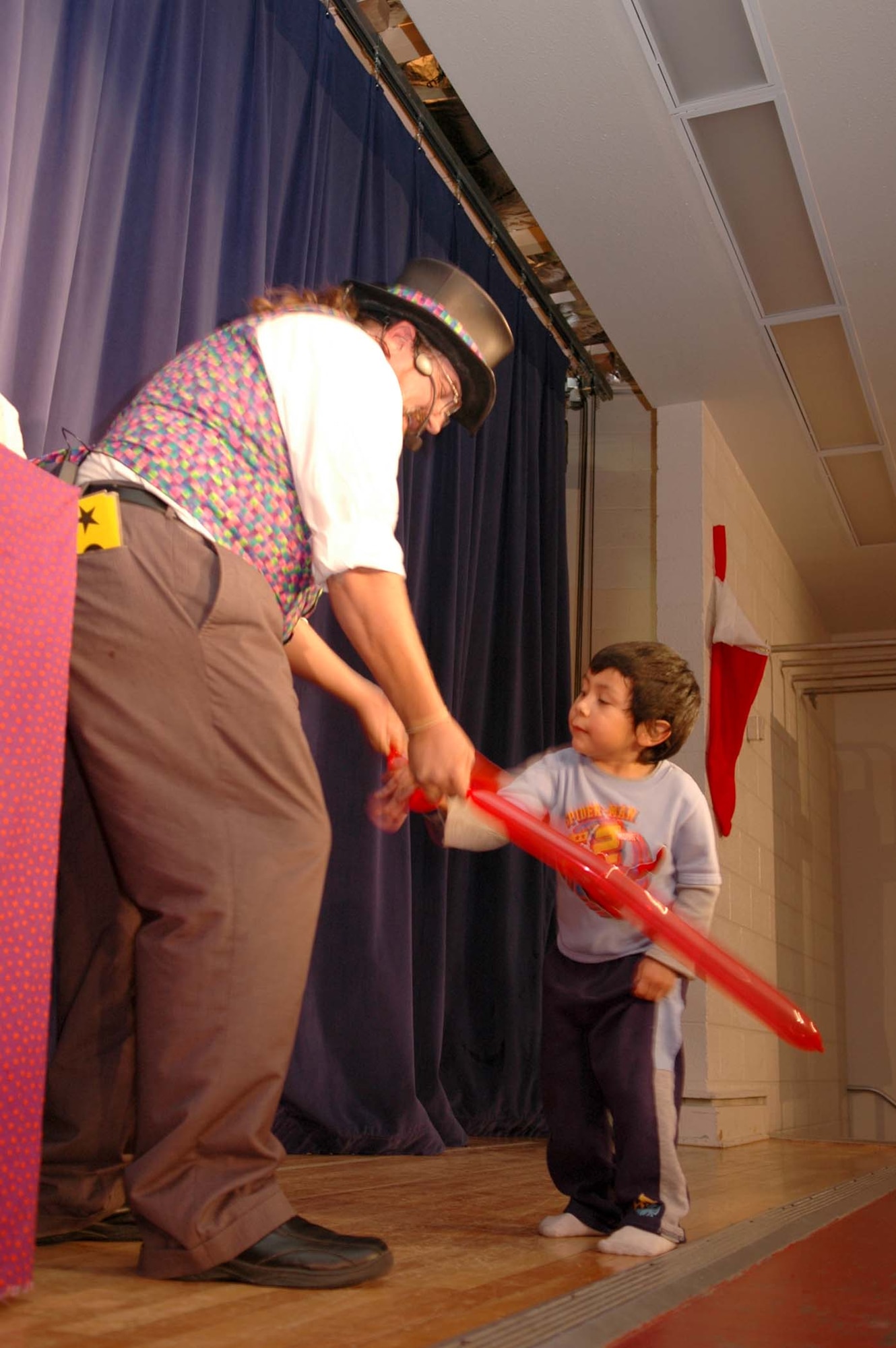 Mr. Jamie O'Hara Magic Guy from Las Cruces makes a ballon animal for Kaiman Ulukita, 4, at the Children's International Festival Saturday. (U.S. photo by Airman Jamal Sutter)