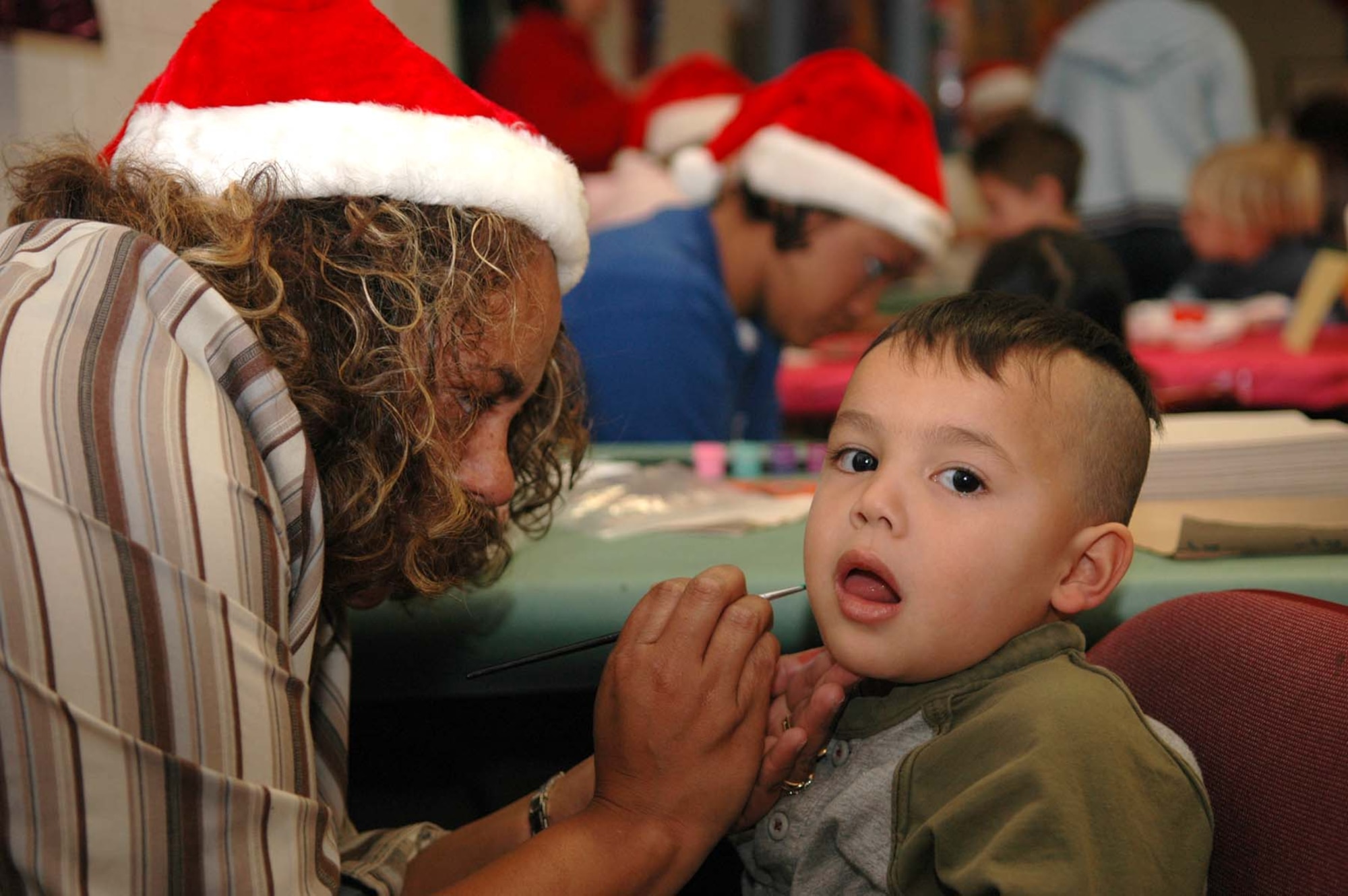 Ms. Cherice Gladney paints 4-year-old Nelson Chun at the Children's International Festival Saturday. (U.S. photo by Airman Jamal Sutter)