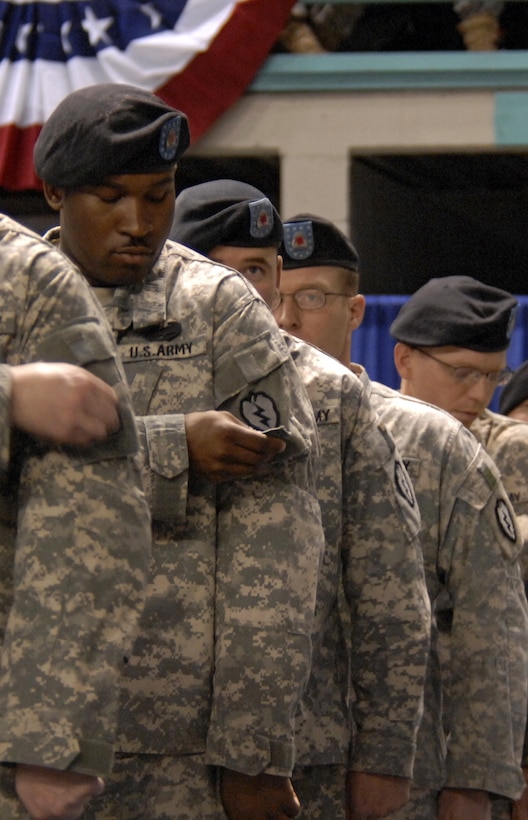 Stryker soldiers remove their 172nd Stryker Brigade Combat Team patches from their uniforms to attach the "Tropic Lightning" patch of the 25th Infantry Division during a reflagging and change of command ceremony in Fairbanks, Alaska, Dec. 14, 2006. The 172nd, which returned after 16 months combat duty in Iraq, was officially redesignated the 25th Infantry Division’s 1st Stryker Brigade Combat Team.