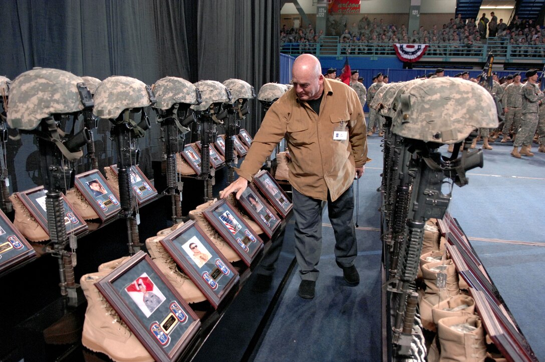 During a Dec. 13, 2006, ceremony outside Fort Wainwright, Alaska, James Trout touches the photo of his grandson Army Spc. Dustin Harris who was killed on April 6, 2006, while serving in Iraq with the 172nd Stryker Brigade Combat Team