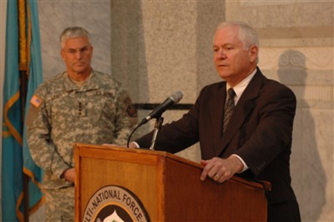 Defense Secretary Robert M. Gates conducts a press conference as U.S. Army Gen. George W. Casey Jr., commander of Multi-National Force - Iraq, looks on at Multi-National Force - Iraq headquarters on Camp Liberty, Iraq, Dec. 20, 2006, following a meeting with top generals.