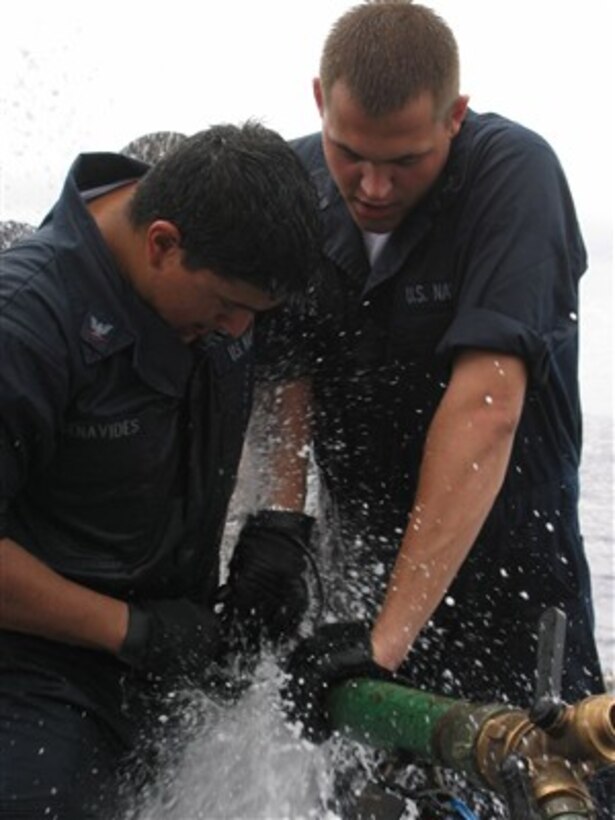 U.S. Navy Petty Officer 2nd Class Michael Murphy (right) and Petty Officer 3rd Class Joshua Benavides try to stop the leak as they compete in the pipe-patching event during the Damage Control Olympics aboard the guided-missile frigate USS Robert G. Bradley (FFG 49) on Dec. 2, 2006.  Murphy and Benavides are Navy damage controlmen.   The Bradley is deployed to the Eastern Pacific in support of counter-narcoterrorism operations.  
