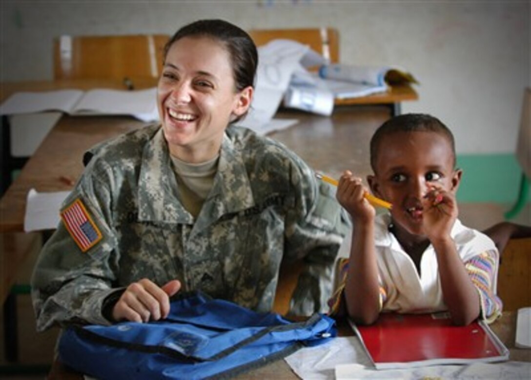 U.S. Army Spc. Danielle Deal visits with a student at the Djibouti City School in Djibouti after handing out school supplies collected by Combined Joint Task Force - Horn of Africa on Dec. 2, 2006.  Deal is deployed with Bravo Company, 489th Civil Action Battalion.  