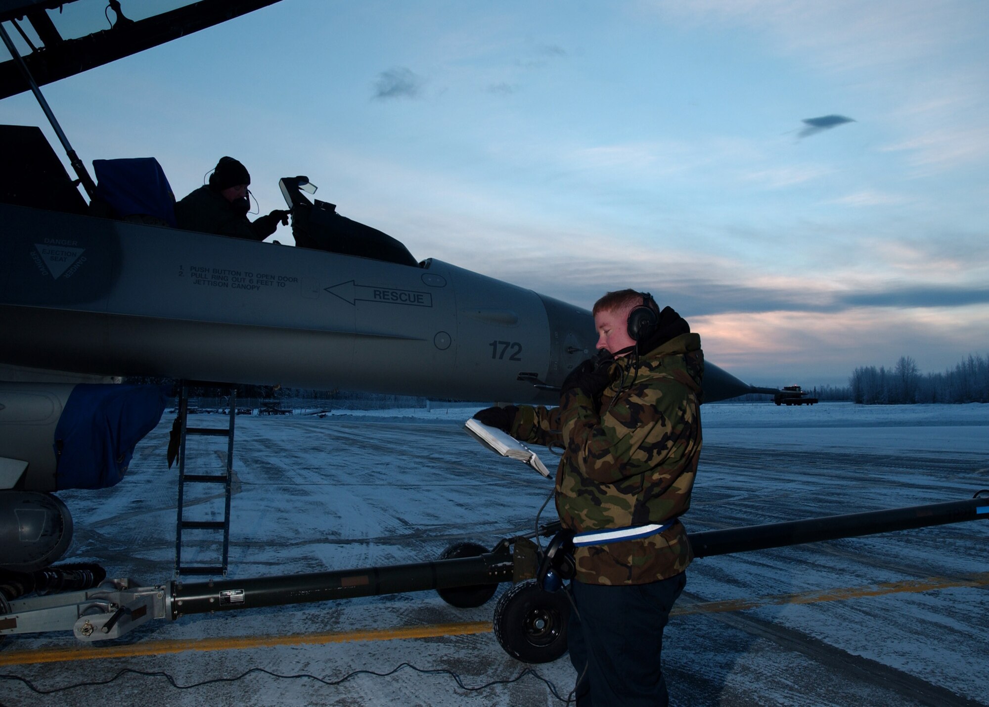 EIELSON AIR FORCE BASE, Alaska -- Staff Sgt. John Eby and Technical Sgt. Eldon Arnaud (sitting in the cockpit), 354 Aircraft Maintenance Squadron, de-fuel an F-16 Fighting Falcon on the Flight Line, Dec. 21. Today is Winter Solstice, the shortest day of the year. At Eielson Air Force Base the sun rose at 1052 and set at 1441 today resulting in a total of 3 hours and 49 minutes from sun up to sun down. This night will be extra dark due to the moon being completely below the horizon all day resulting in 0% moonlight illumination. 
(U.S. Air Force Photo by Airman Jonathan Snyder)