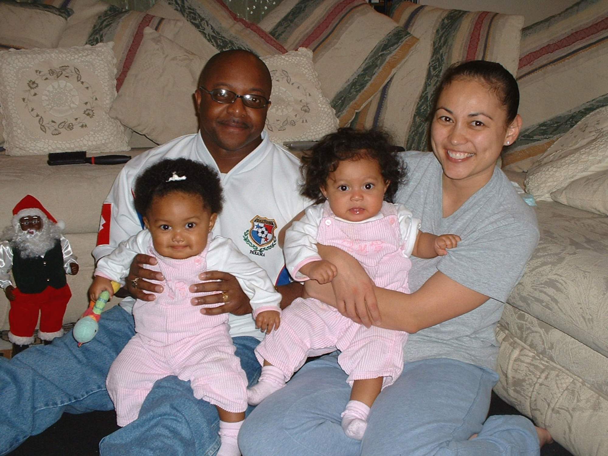 Tech. Sgts. Flor and Fernando Richards pose for a photo opportunity with their 10-month-old twin daughters, Damaris Isabel and Analiza Gabriela. (U.S. Air Force photo/Staff Sgt. Kevin Nichols)
