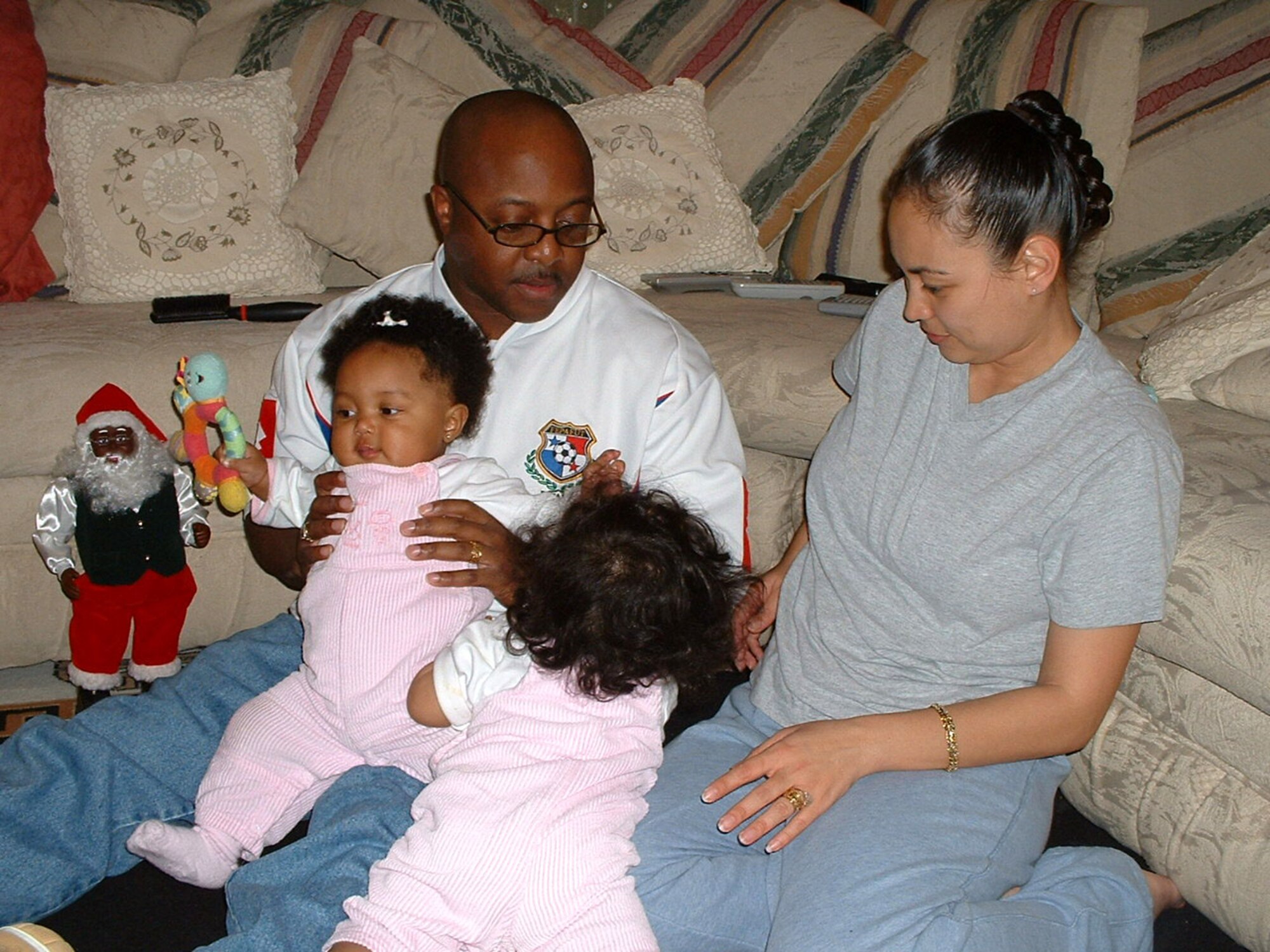 Tech. Sgts. Flor and Fernando Richards tend to their 10-month-old twin daughters.  The couple keeps busy during the holidays by doing things as a family and starting new holiday traditions with their daughters. (U.S. Air Force photo/Staff Sgt. Kevin Nichols)