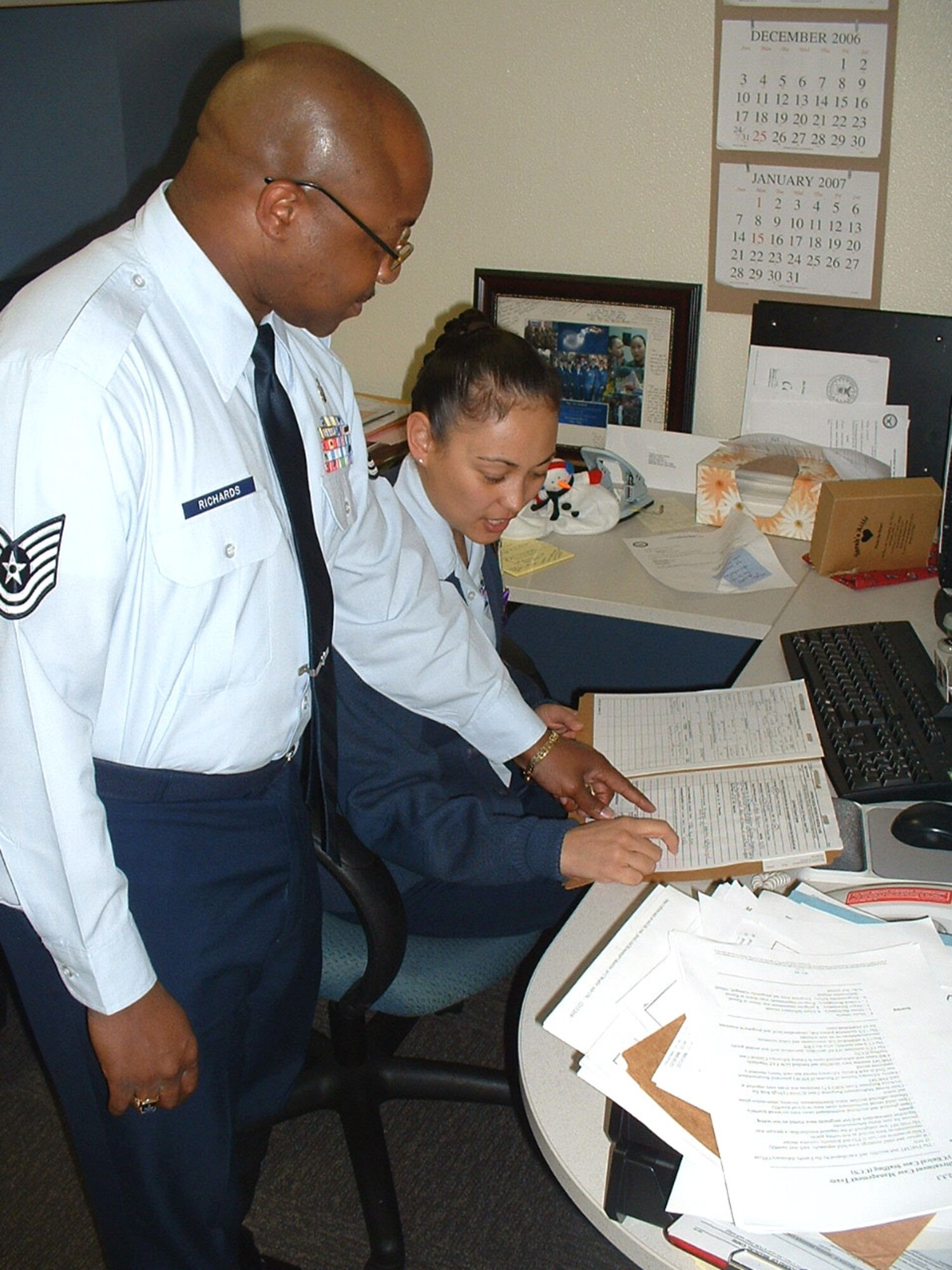 Tech. Sgts. Flor and Fernando Richards discuss a patient record at Kadena Air Base's Life Skills Center on Okinawa, Japan.  Both work as mental health technicians and see an influx of patients during the holidays.  (U.S. Air Force photo/Staff Sgt. Kevin Nichols)