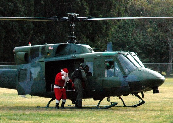 Santa steps out of a 76th Helicopter Squadron UH-1N Huey at Crestview Elementary School on Vandenberg Air Force Base, Calif.  Santa came to the school to present student representatives with bags of candy canes for their classrooms.  (U.S. Air Force photo by Staff Sgt. Raymond Hoy)