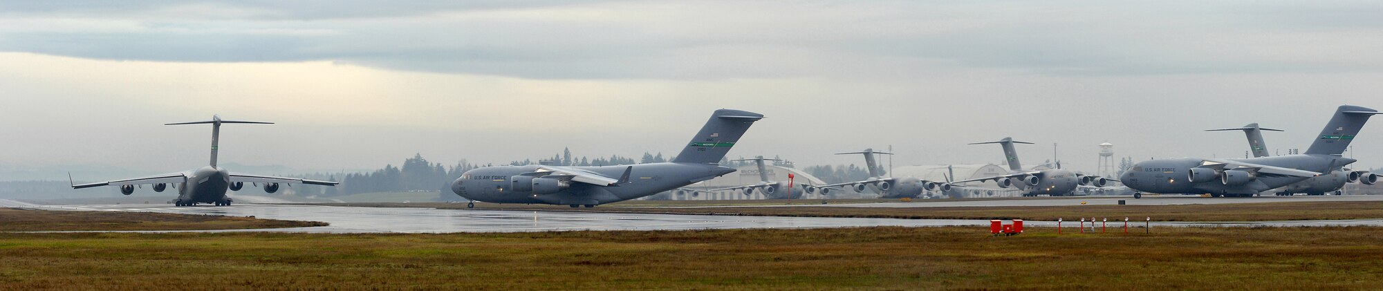 Several C-17 Globemaster III's wait on the flightline prior to launching as part of a 10-ship formation training exercise Dec. 20 at McChord Air Force Base, Wash. Key players included the 62nd Airlift Wing and 446th Maintenance Group, which will generate, launch and recover the aircraft. (U.S. Air Force illustration/Abner Guzman)
