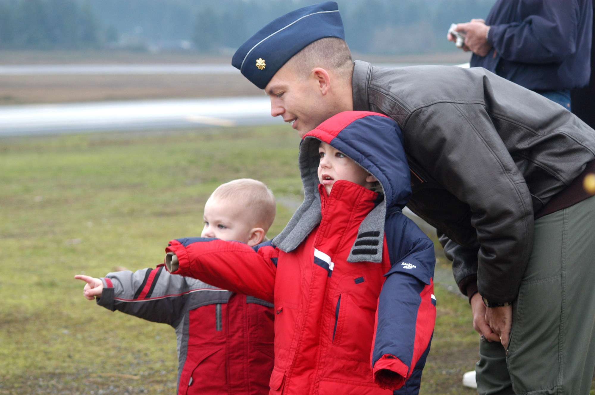 Maj. Jim Dittus and his sons, Josh and Jake,  watch a C-17 Globemaster III formation training excercise Dec. 20 at McChord Air Force Base, Wash. Major Dittus is assigned to the 7th Airlift Squadron. (U.S. Air Force photo/Adamarie Lewis Page)