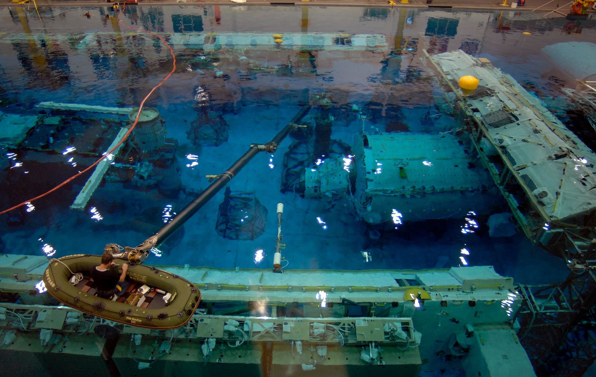 A technician works on the full-size mock-up of the International Space Station inside the Neutral Buoyancy Lab Dec. 15 at the Johnson Space Center in Houston. The lab is the world's largest indoor pool containing 6.2 million gallons of water, which is re-filtered every 18 hours. (U.S. Air Force photo/Tech. Sgt. Larry Simmons)