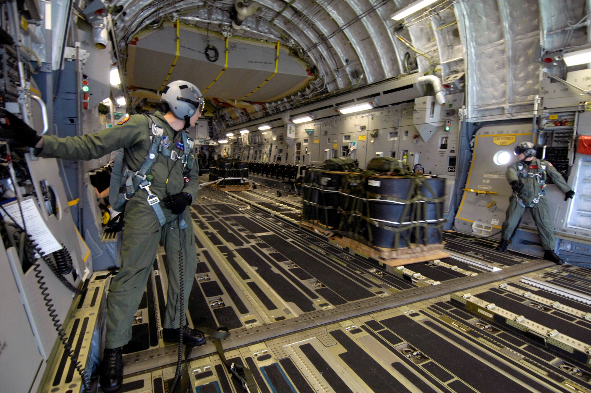Tech. Sgt. Ken Bragg and Staff Sgt. Allen Culbreth watch as a container delivery system is released from a C-17 Globemaster III during an airdrop mission Dec. 14 over Andersen Air Force Base, Guam. The C-17 from Hickam Air Force Base, Hawaii, is conducting airdrop training at Andersen AFB. The Airmen are loadmasters with the 535th Airlift Squadron. (U.S. Air Force photo/Tech. Sgt. Shane A. Cuomo) 
