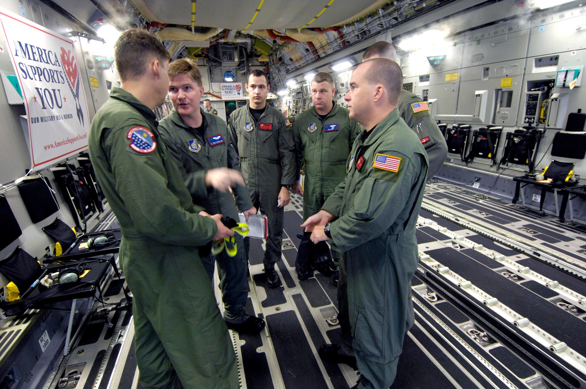 Aircrew members go over a safety briefing before conducting an airdrop mission on a C-17 Globemaster III Dec. 14 at Andersen Air Force Base, Guam. The C-17 from Hickam Air Force Base, Hawaii, is conducting airdrop training at Andersen AFB. The Airmen are from the 535th Airlift Squadron. (U.S. Air Force photo/Tech. Sgt. Shane A. Cuomo) 
