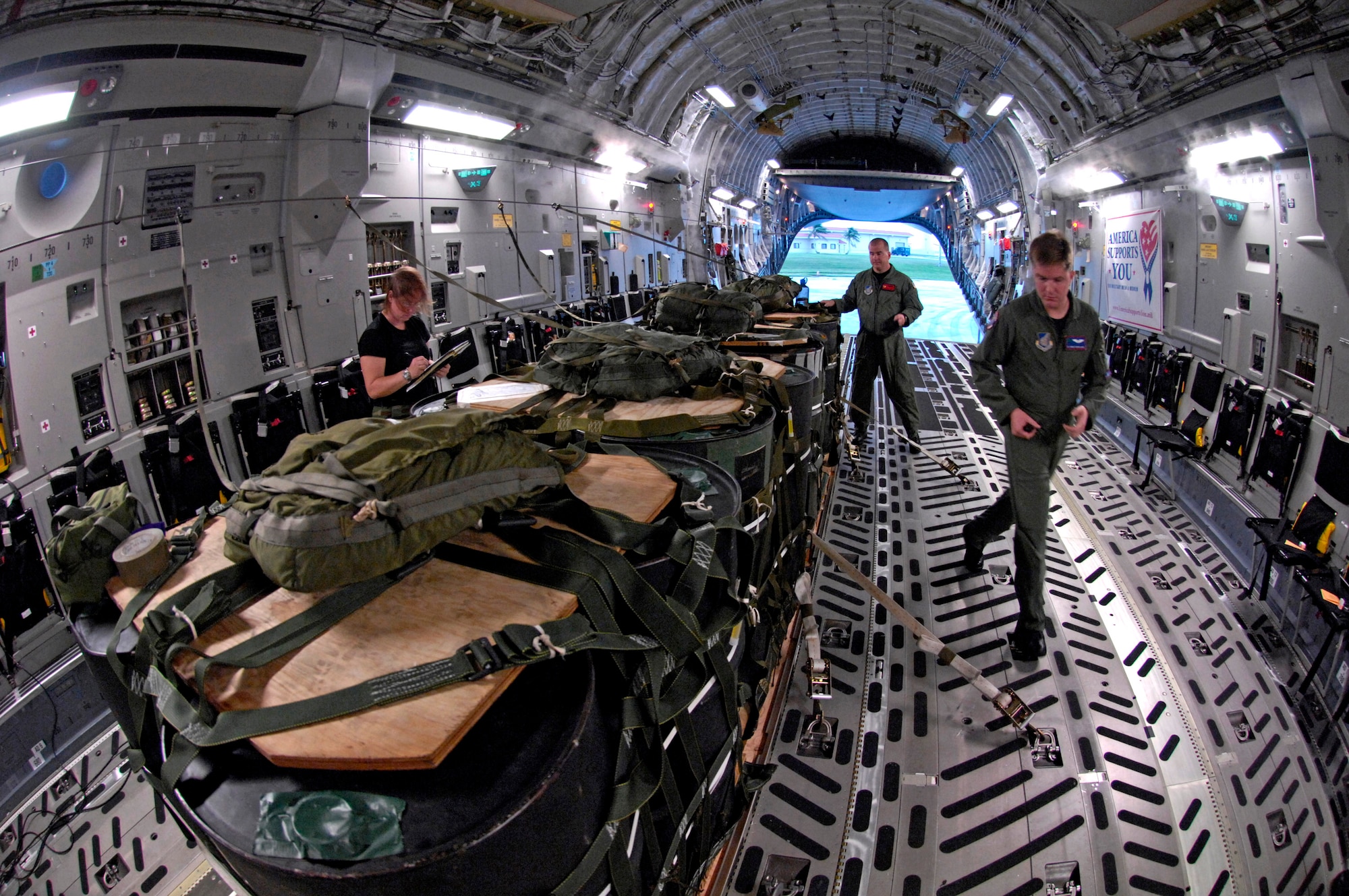 Aircrew members inspect a container delivery system on a C-17 Globemaster III before conducting an airdrop Dec. 14 at Andersen Air Force Base, Guam. The C-17 from Hickam Air Force Base, Hawaii, is conducting airdrop training at Andersen AFB. The Airmen are from the 535th Airlift Squadron. (U.S. Air Force photo/Tech. Sgt. Shane A. Cuomo) 
