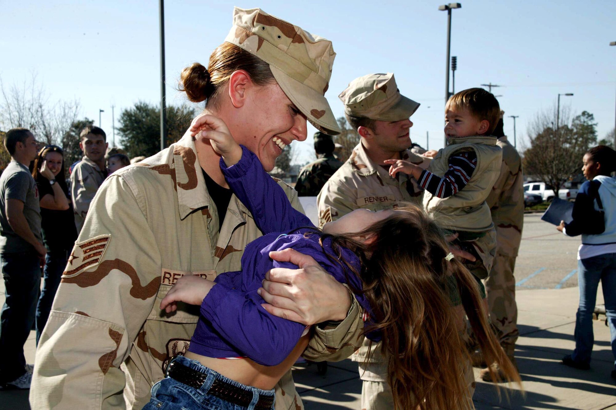 Staff Sergeants Emily and Ryan Renner, greet their children, Mikalyn and Brady, Dec. 12 upon the sergeants' return from seven month deployments to Afghanistan to Shaw Air Force Base, S.C. Both sergeants are from the 20th Security Forces Squadron. (U.S. Air Force photo/Tarsha Storey)