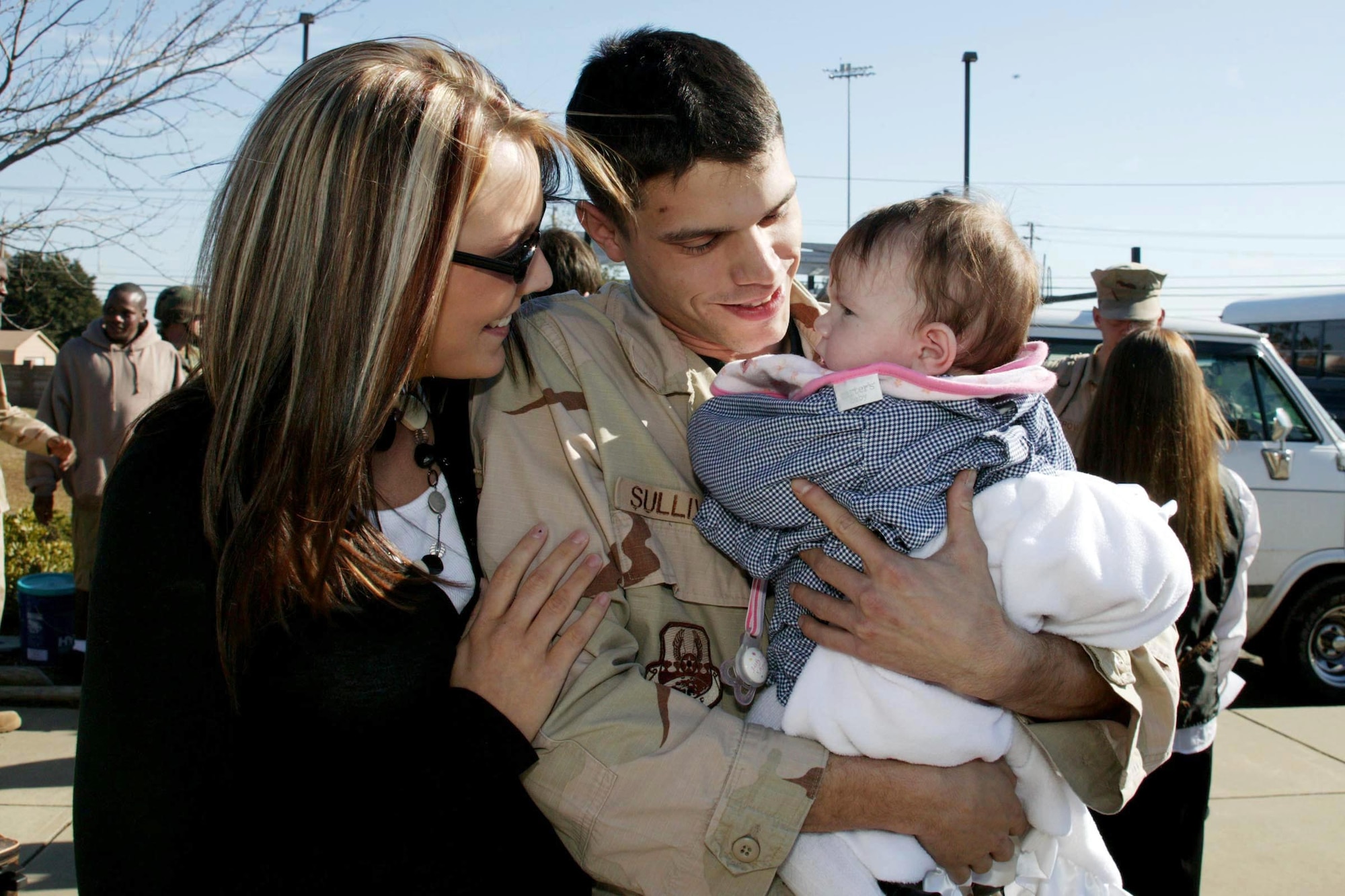 Airman 1st Class Shawn Sullivan holds his four-month-old daughter, Peyton, for the first time Tuesday as his wife, Faryn, looks on Dec. 12 at Shaw Air Force Base, S.C. Airman Sullivan is assigned to the 20th Security Forces Squadron and was deployed for seven months supporting Operation Enduring Freedom in Afghanistan. (U.S. Air Force photo/Tarsha Storey)