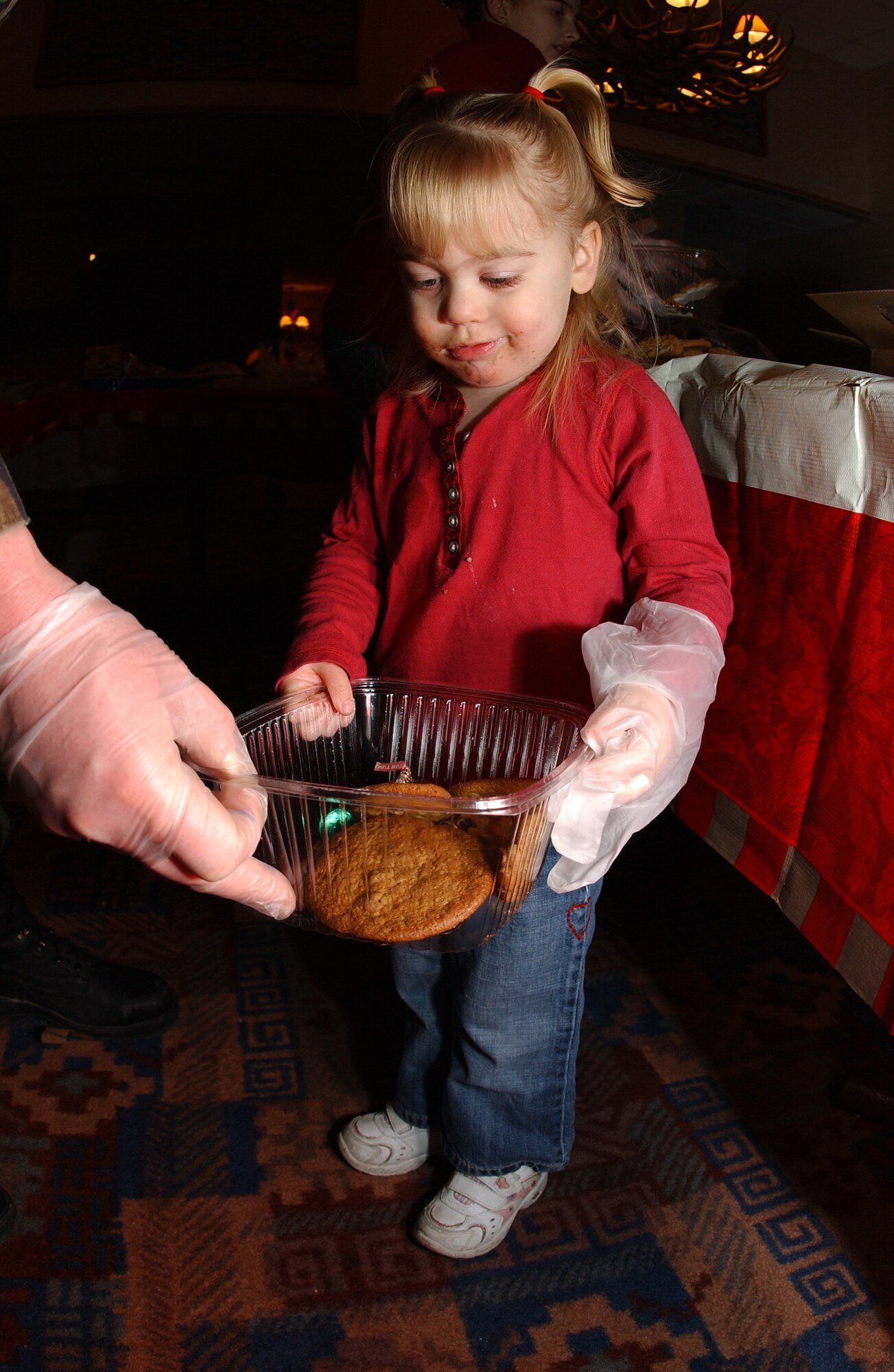 EIELSON AIR FORCE BASE, Alaska -- Samantha Sova daughter of Cpt. Sova helps pack cookies in annual Operation Cookie Crunch on Dec. 15. Hundreds of dozens of cookies are packaged up each year and delivered to families of deployed airmen and single airmen stationed on Eielson AFB. The event is not unique to Eielson, but more of an Air Force tradition. 
(U.S. Air Force Photo by Senior Airman Anthony Nelson Jr)