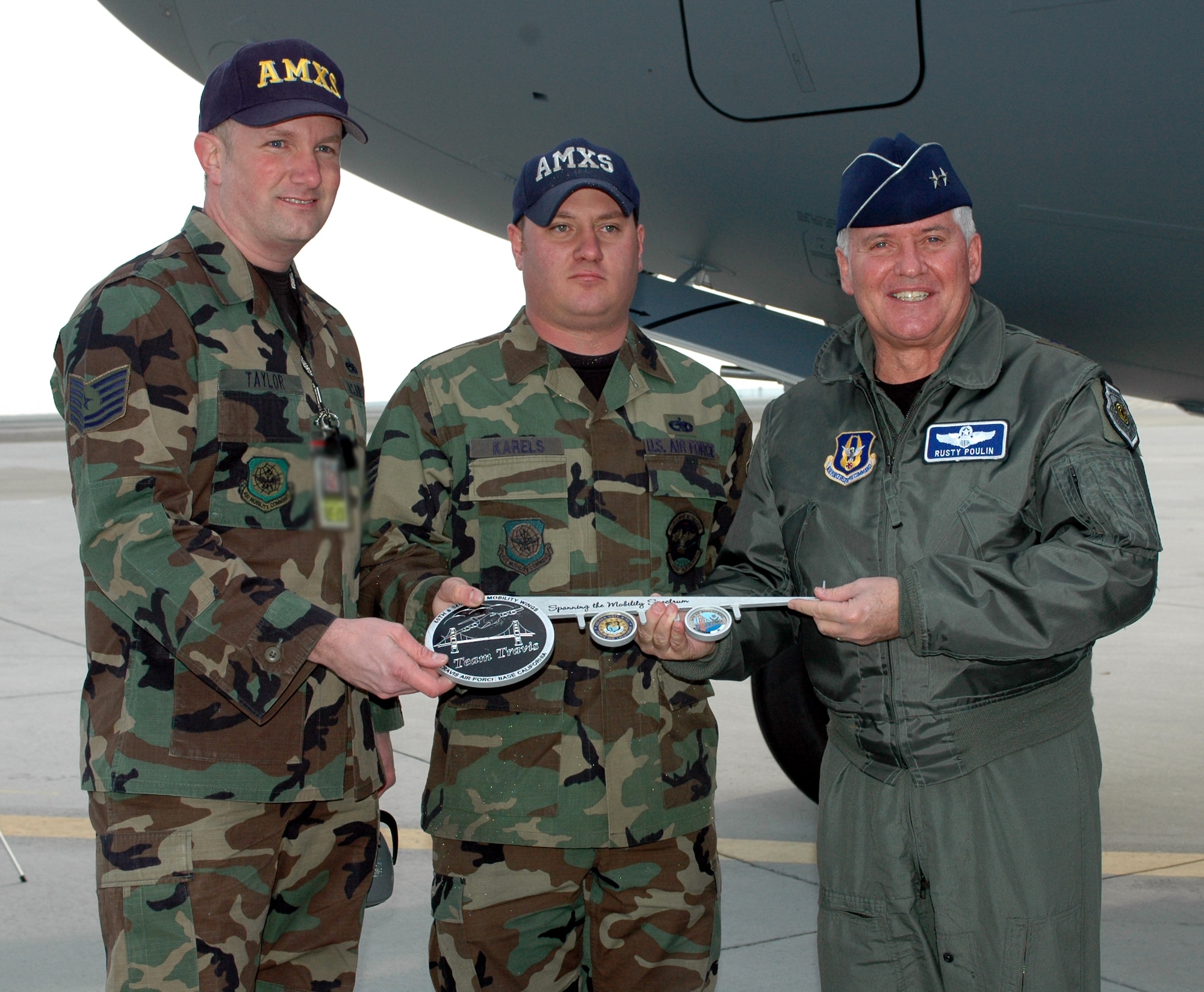Maj. Gen. Allan Poulin, Air Force Reserve Command vice commander, present the "Spirit of the Golden Gate" aircraft key to Tech Sgt. Daniel Taylor, 945th Aircraft Maintenance Squadron and Staff Sgt. Randy Karels, 860th Aircraft Maintenance Squadron during the arrival ceremony Dec. 20. The sergeants are the aircraft's crew chiefs. (U.S. Air Force photo by Staff Sgt. Candy Knight)