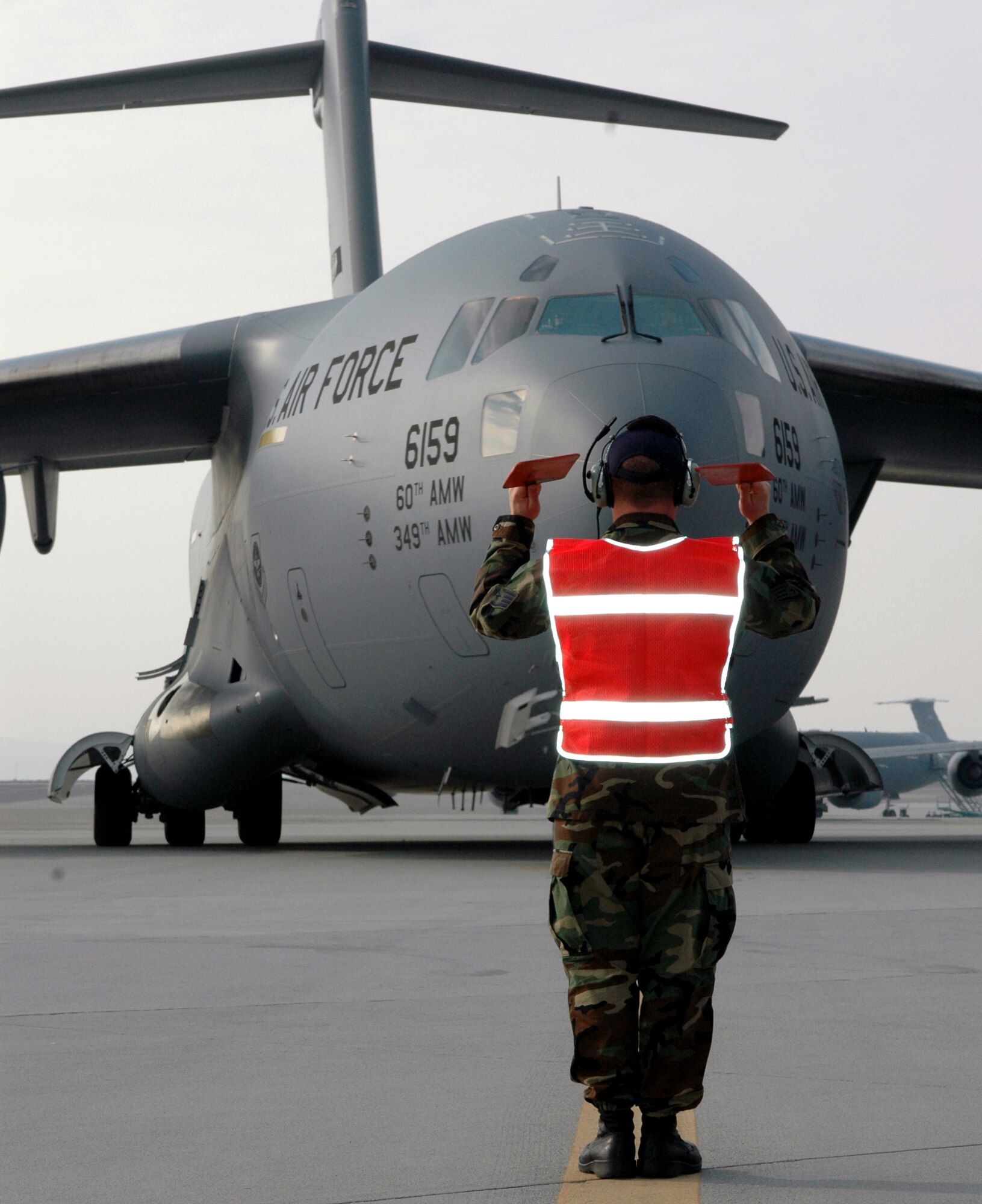 Staff Sgt. Randy Karels marshals in Travis' newest C-17 Globemaster III Dec. 20. Nicknamed the "Spirit of the Golden Gate," the aircraft was piloted by Maj. Gen. Allan Poulin, Air Force Reserve Command vice commander. Sergeant Karels is one of the aircraft's crew chiefs and is assigned to the 860th Aircraft Maintenance Squadron. (U.S. Air Force photo by Staff Sgt. Candy Knight)
