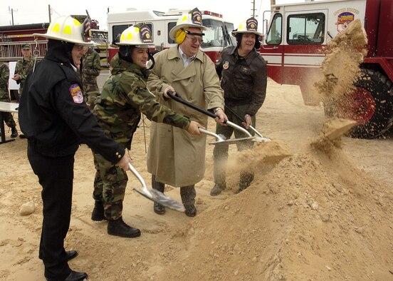 Dirt flies as Mr. Wayne Mello, 49th Civil Engineer Squadron fire chief, Maj. Nathan Clemmer, 49 CES, Mr. Howard Moffett, retired deputy base civil engineer, and Col. David Moore, 49th Fighter Wing vice commander, perform the ceremonial ground breaking for two new fire stations coming to Holloman Tuesday. (U.S. Air Force photo by Airman Michael Means)