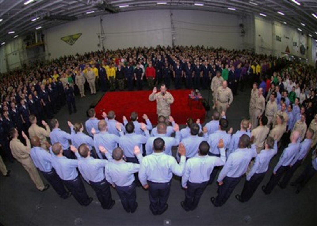 Chief of Naval Operations Adm. Mike Mullen re-enlists 34 sailors aboard the USS Dwight D. Eisenhower while under way in the Persian Gulf, Dec. 21, 2006.