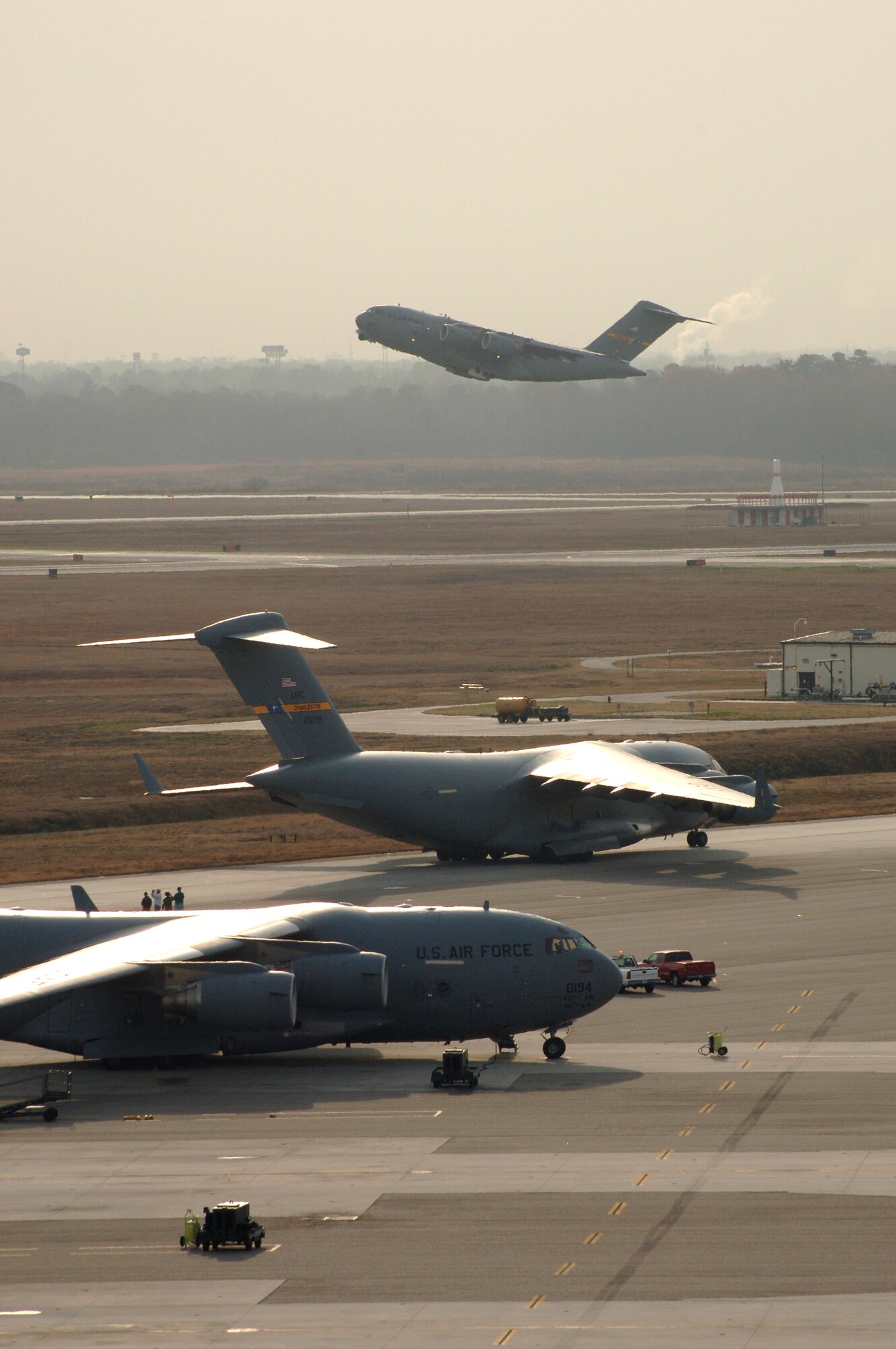 A C-17 Globemaster III takes off as other aircraft prepare to launch Dec. 21 at Charleston Air Force Base, S.C. Aircrews consisting of active-duty Airmen and reservists train simulating the complexity of this type of mission. The training mission included airdrops over North Auxiliary Airfield in Orangeburg, S.C., aerial refueling and low-level tactical training. Charleston AFB members launched the largest formation of C-17's to take flight from a single base. (U.S. Air Force photo/Staff Sgt. April Quintanilla)