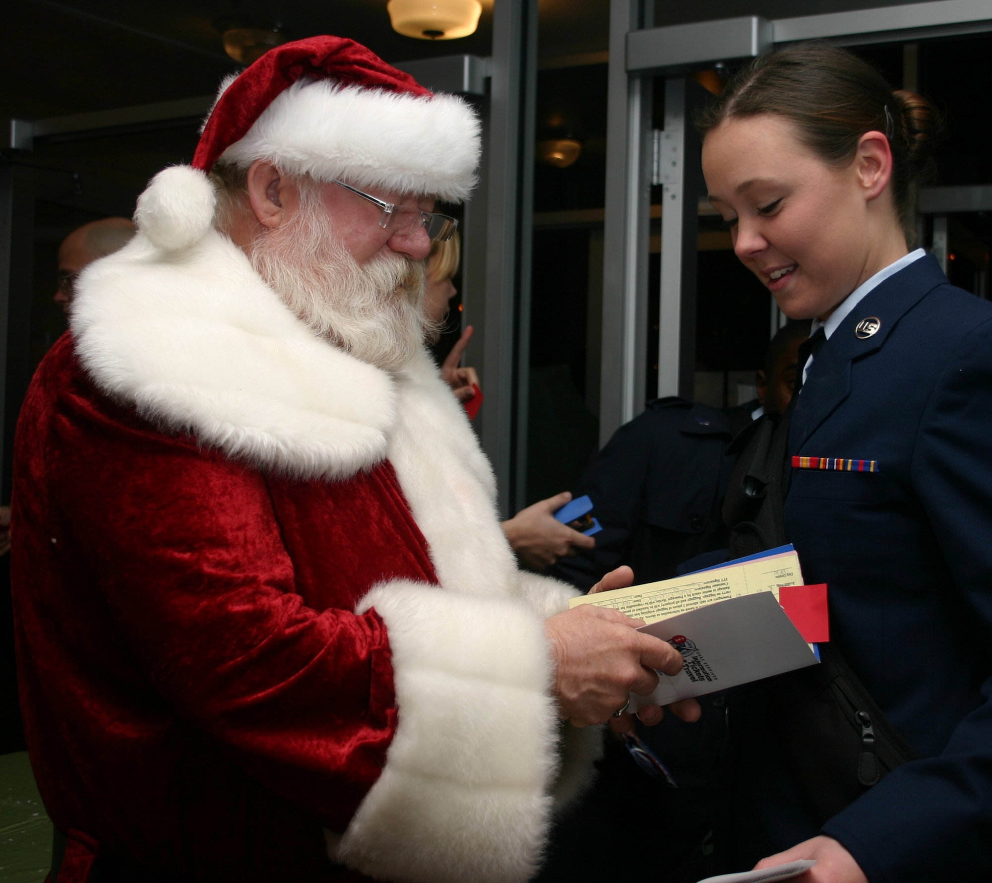 Jolly Old St. Nick takes Airman Megan McCulloh's airline tickets and checks them twice before she leaves Sheppard Dec. 22 during the Holiday Exodus. Airman McCulloh, an Airman-in-training at the 363rd Training Squadron, and thousands of other Airmen made the annual holiday trek to different areas of the country. (U.S. Air Force photo/Mike McKito)