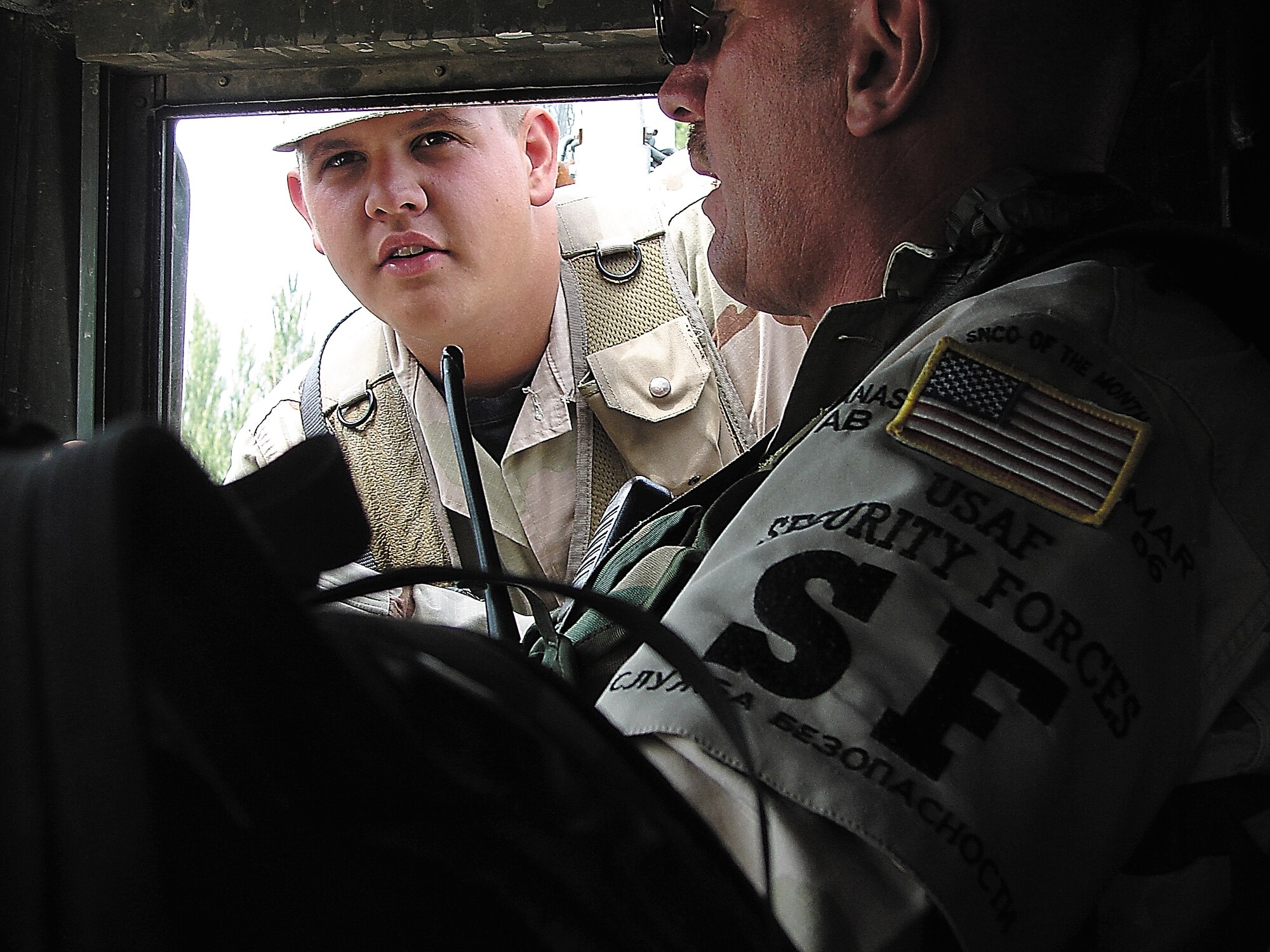 MANAS AIR BASE, Kyrgyzstan -- Senior Airman Jonathan Gray, an Air Force reservist with the 442nd Security Forces Squadron deployed here, checks the security status of fellow 442nd SFS member, Staff Sgt. Edwin Crampton, upon his return from a patrol. US Air Force photo / Tech. Sgt. Daniel Heiser