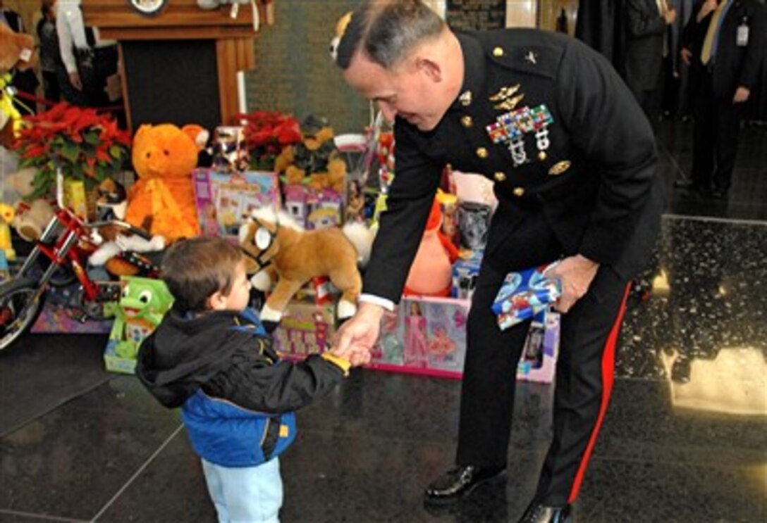 U.S. Marine Corps Brig. Gen. Robert Milstead accepts a Toys for Tots program donation from 2-year-old Matthew Wurmser at the Harry S. Truman building in Washington, Dec. 20. The State Department donated more than 5,000 toys. 
