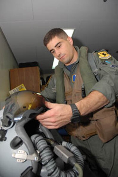 Capt. Kris Person checks his helmet to make sure it is in proper working order prior to a flight. Captain Person is one of several Airmen who will be spending the holidays flying training missions upholding the Treaty of Mutual Agreement between the United States and Japan. The captain is assigned to the 18th Operations Support Squadron as a electronic combat officer and flies with the 44th Fighter Squadron. (U.S. Air Force photo/Senior Airman Joshua Garcia)