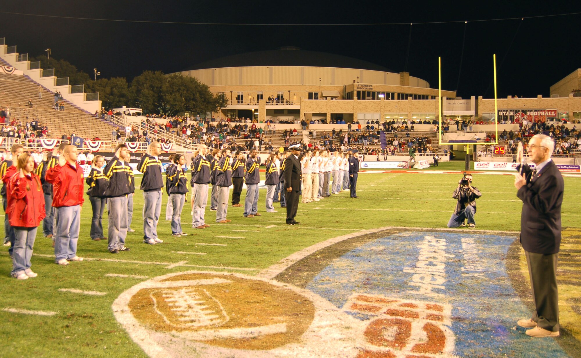 Deputy Secretary of Defense Gordon England (right) administers the oath of enlistment to more than 100 recruits from all the armed forces during halftime at the Bell Helicopter Armed Forces Bowl in Fort Worth, Texas, Dec. 23. The University of Utah Utes defeated the Golden Hurricanes of the University of Tulsa, 25-13. (U.S. Air Force photo/Annette Crawford)