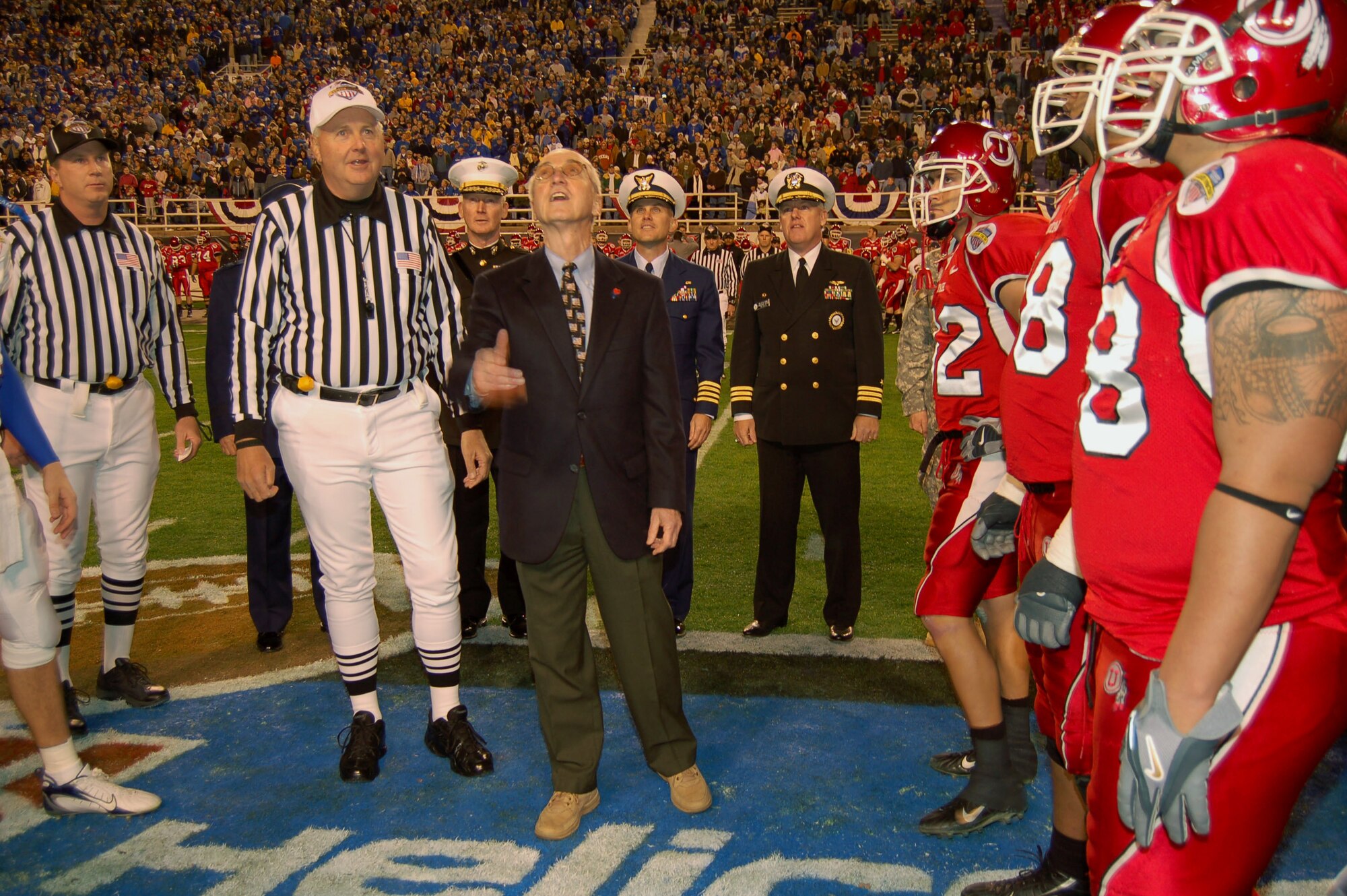 Deputy Secretary of Defense Gordon England tosses the coin before the start of the Bell Helicopter Armed Forces Bowl at Amon G. Carter Stadium in Fort Worth, Texas, Dec. 23. The University of Utah Utes defeated the Golden Hurricanes of the University of Tulsa, 25-13. (U.S. Air Force photo/Annette Crawford)