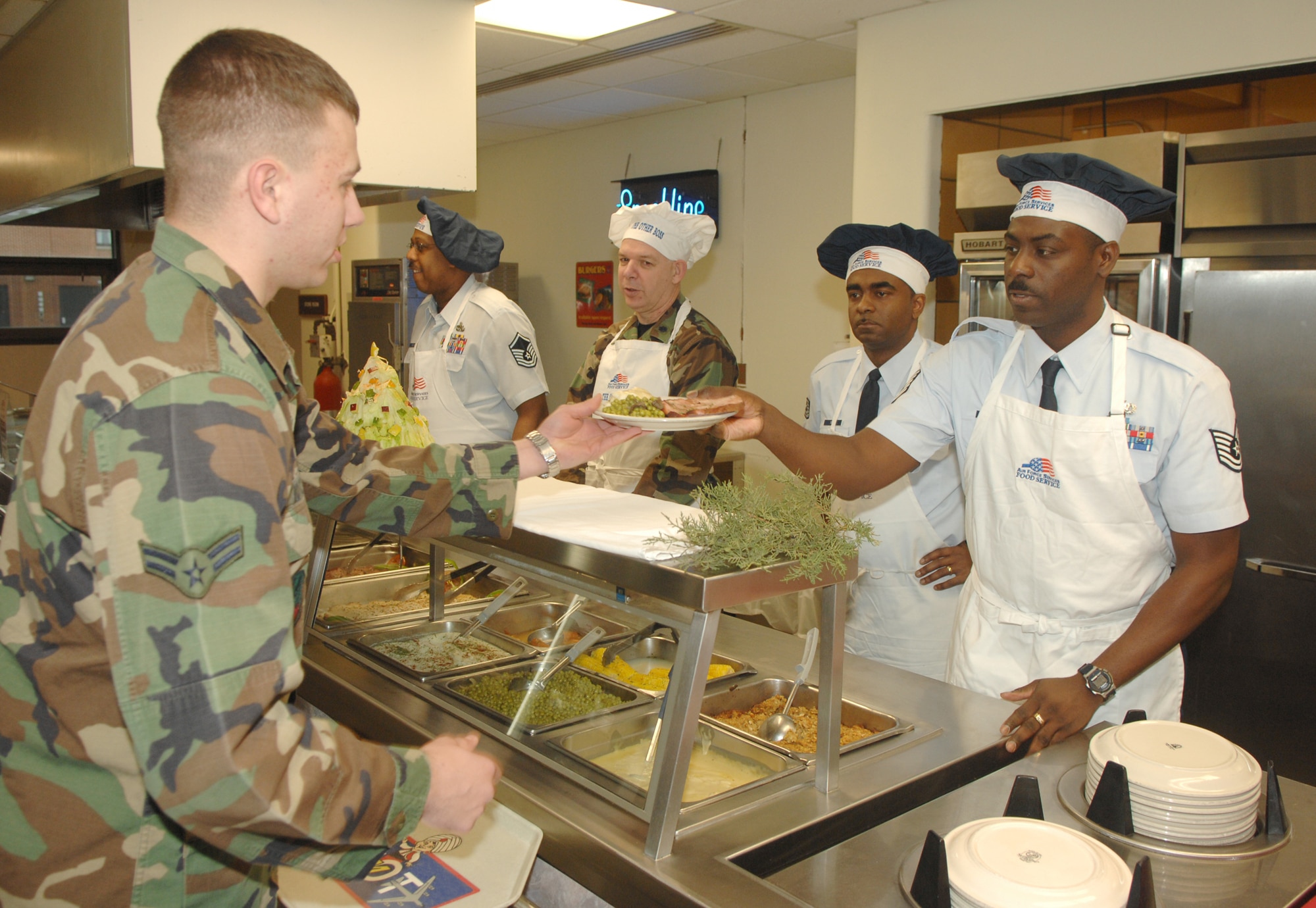 Airman First Class Johnathan Royce, 5th Security Forces Squadron, receives his plate at the Dakota Inn Dining Facility Christmas Day.  On holidays suchs as Christmas and Thanksgiving, the dining facility is staffed by members of Minot Air Force Base leadership and other volunteers,  who serve lunch and dinner to dormitory residents. (U.S. Air Force photo by Airman 1st Class Christopher Boitz)