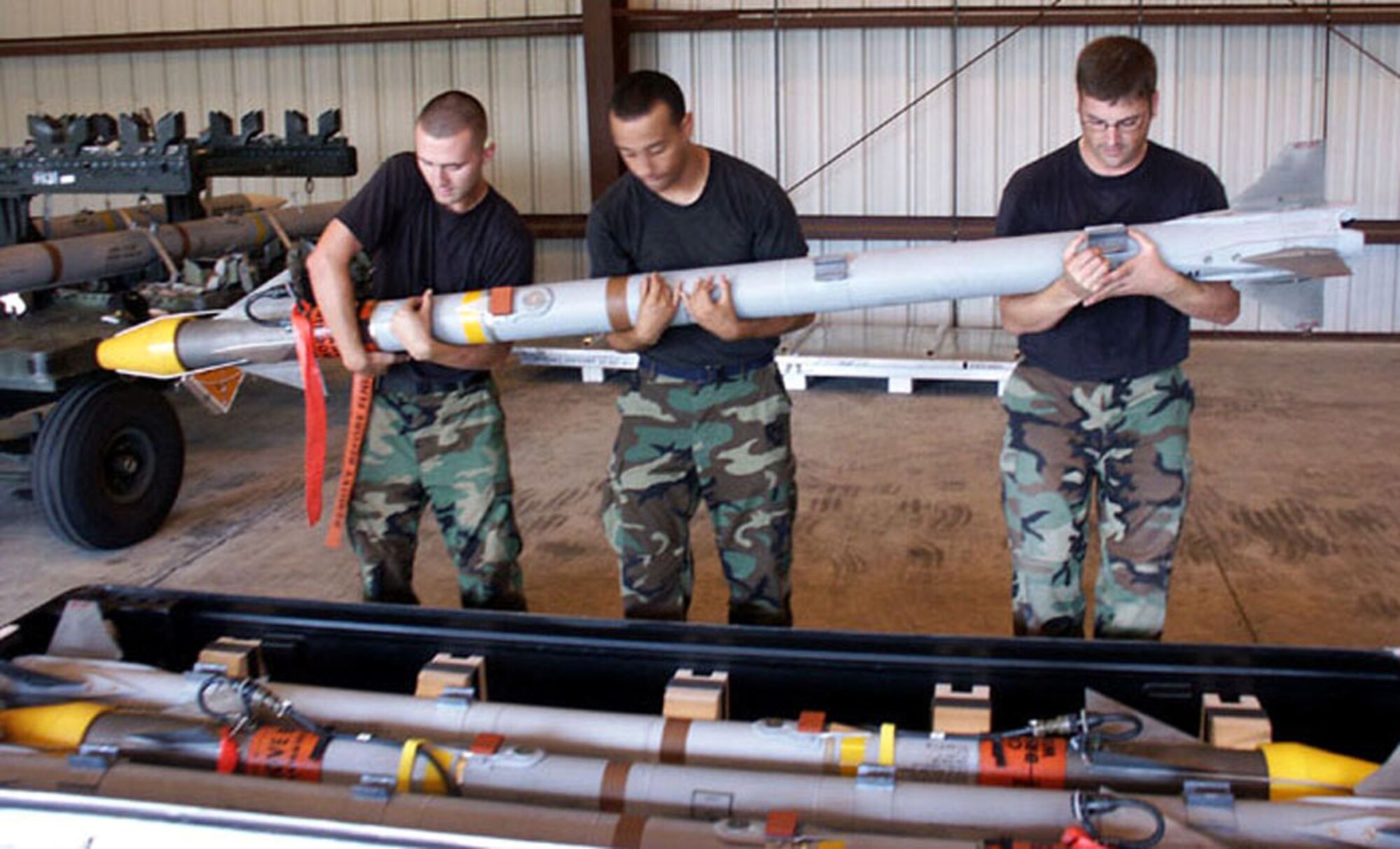 EGLIN AIR FORCE BASE, Fla. -- (Left to right) Aiman 1st Class Philip Downs and Antonio Rivera and Staff Sgt. Reuben Bellotte, 33d MXS precision-guided munitions specialists, hand-carry an Air Interdiction Missile 9X to a casket of four for
operational checks and storage Oct. 2 in a munitions work hangar. (U.S. Air Force photo/ Staff Sgt. Phillip O. Butterfield)