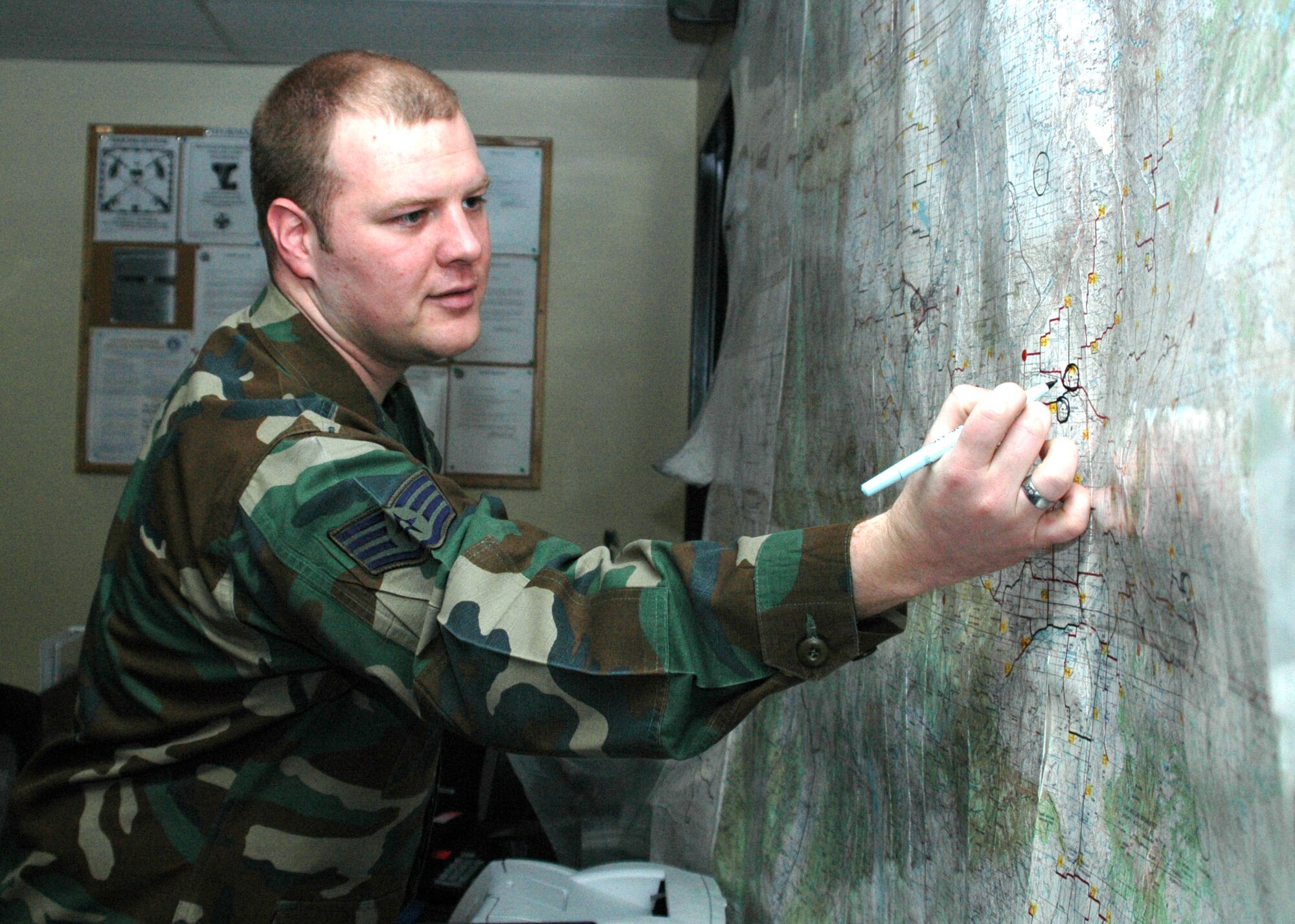 Staff Sgt. Charles Gillman plots movement of security forces and maintenance vehicles within the 25,000-square-mile missile complex while on duty at the Missile Security Control Center at Malmstrom Air Force Base, Mont. (U.S. Air Force photo/Airman Emerald Ralston)