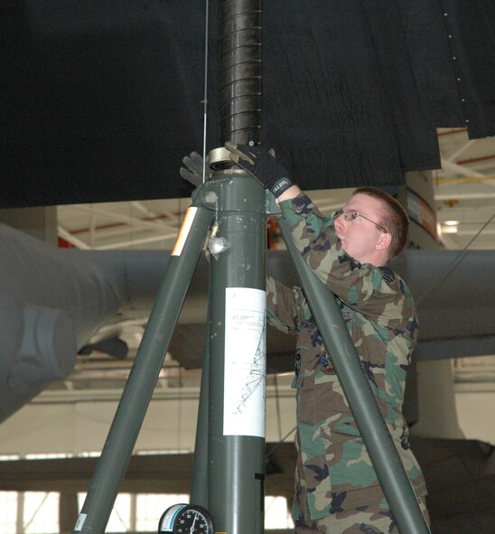 YOUNGSTOWN AIR RESERVE STATION, Ohio—Air Force Reserve Airman 1st Class Greg Spencer, a crew chief with the 910th Maintenance Squadron, sets up a hydraulic jack stand underneath the wing of a C-130 here.  The aircraft was about to be raised off the floor of an aircraft maintenance hangar so the aircraft nose strut could be replaced during routine maintenance operations.  U.S. Air Force photo/Master Sgt. Bryan Ripple.