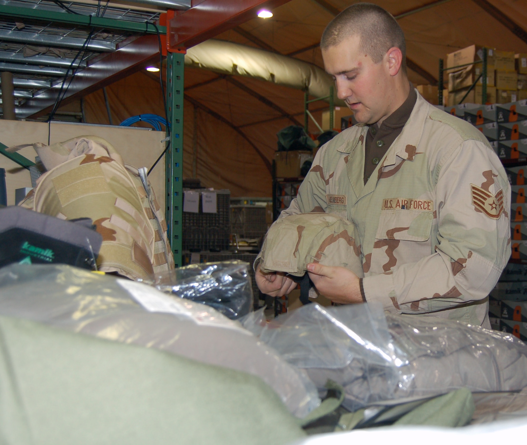 Staff Sgt. Joshua Hjelmberg, 376th Expeditionary Theater Distribution Center technician, prepares a Kevlar helmet and equipment for issue to Airmen headed to Afghanistan. Sergeant Hjelmberg is deployed from the 92nd Logistics Readiness Squadron at Fairchild Air Force Base, Wash. (U.S. Air Force photo/Master Sgt. Mitch Gettle)