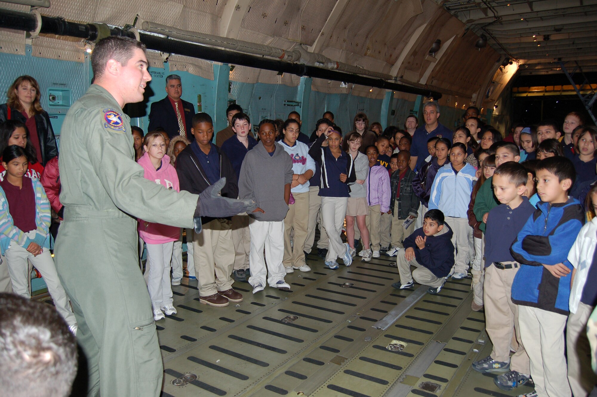Senior Airman David Fink, a reserve loadmaster from the 433rd Airlift Wing, gives students from Radiance Academy a tour of the cargo bay on a C-5 Galaxy during a recent school visit. 