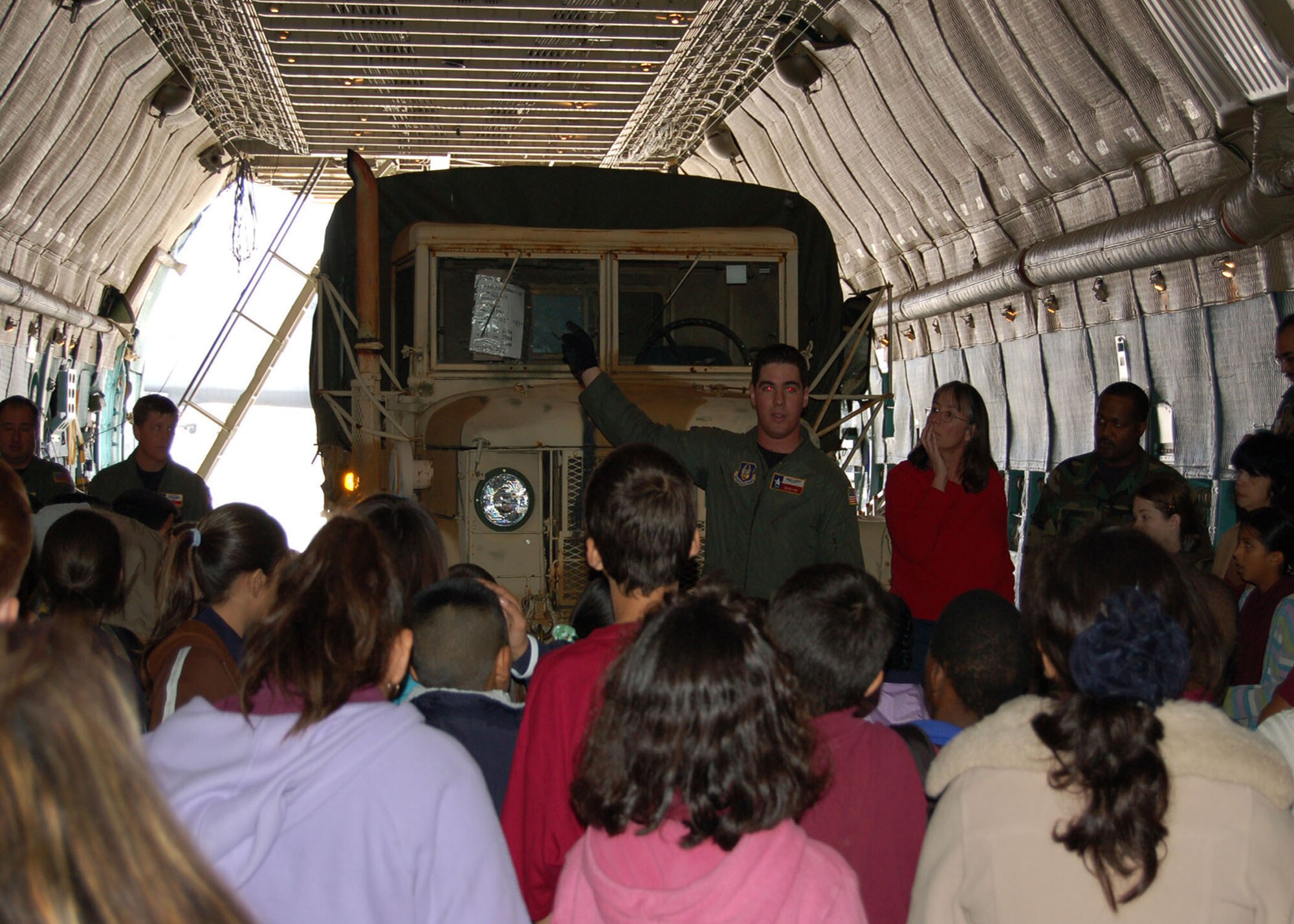 Senior Airman David Fink, a reserve loadmaster from the 433rd Airlift Wing, shows students from Radiance Academy how to load cargo on a C-5 Galaxy. 