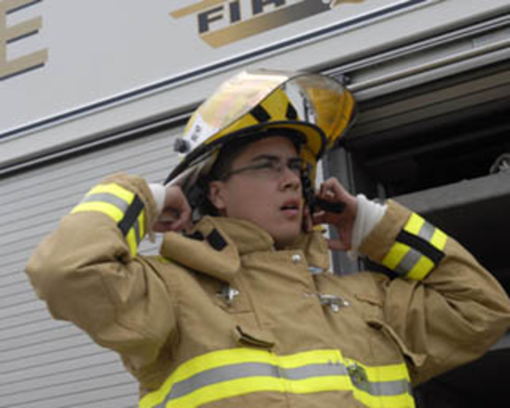 KADENA AIR BASE, Japan -- Airman 1st Class Ricardo Torrez Jr. dons his helmet during a training event Wednesday Dec. 13, 2006 at Kadena Air Base, Okinawa, Japan.  Airman Torrez is an 18th Civil Engineer Squadron firefighter and will be on duty during the holiday season.  (Photo by Airman 1st Class Sheila DeVera) 