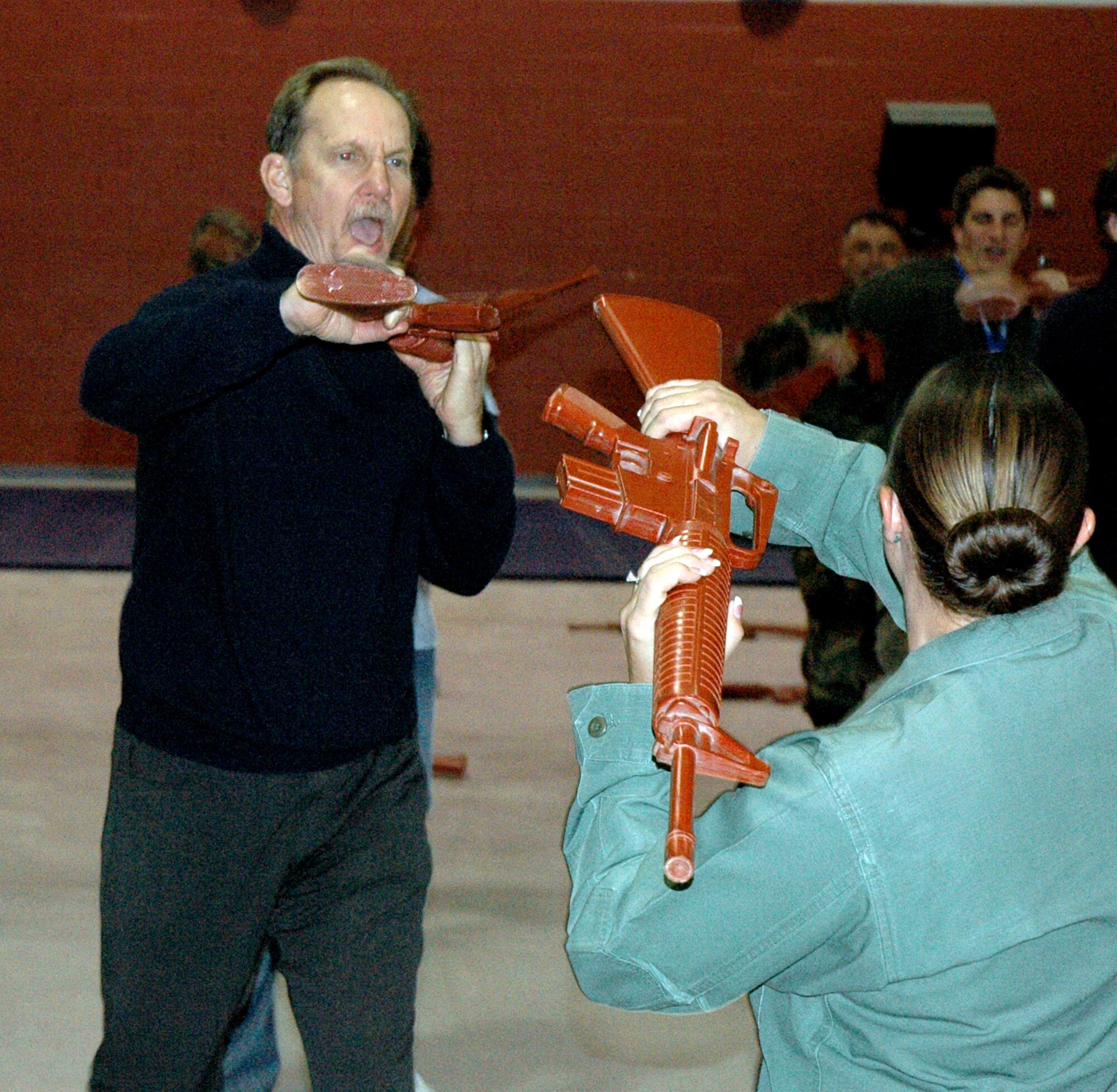 Actor Michael O'Neill practices some self-defense tactics with instructor Rhonda Battles using an M-16 training aid while visiting Lackland Air Force Base, Texas, during a National Civic Outreach Program tour.  Ms. Battles is with the 343rd Training Squadron.  (U.S. Air Force photo/Tech. Sgt. Cortchie Welch)