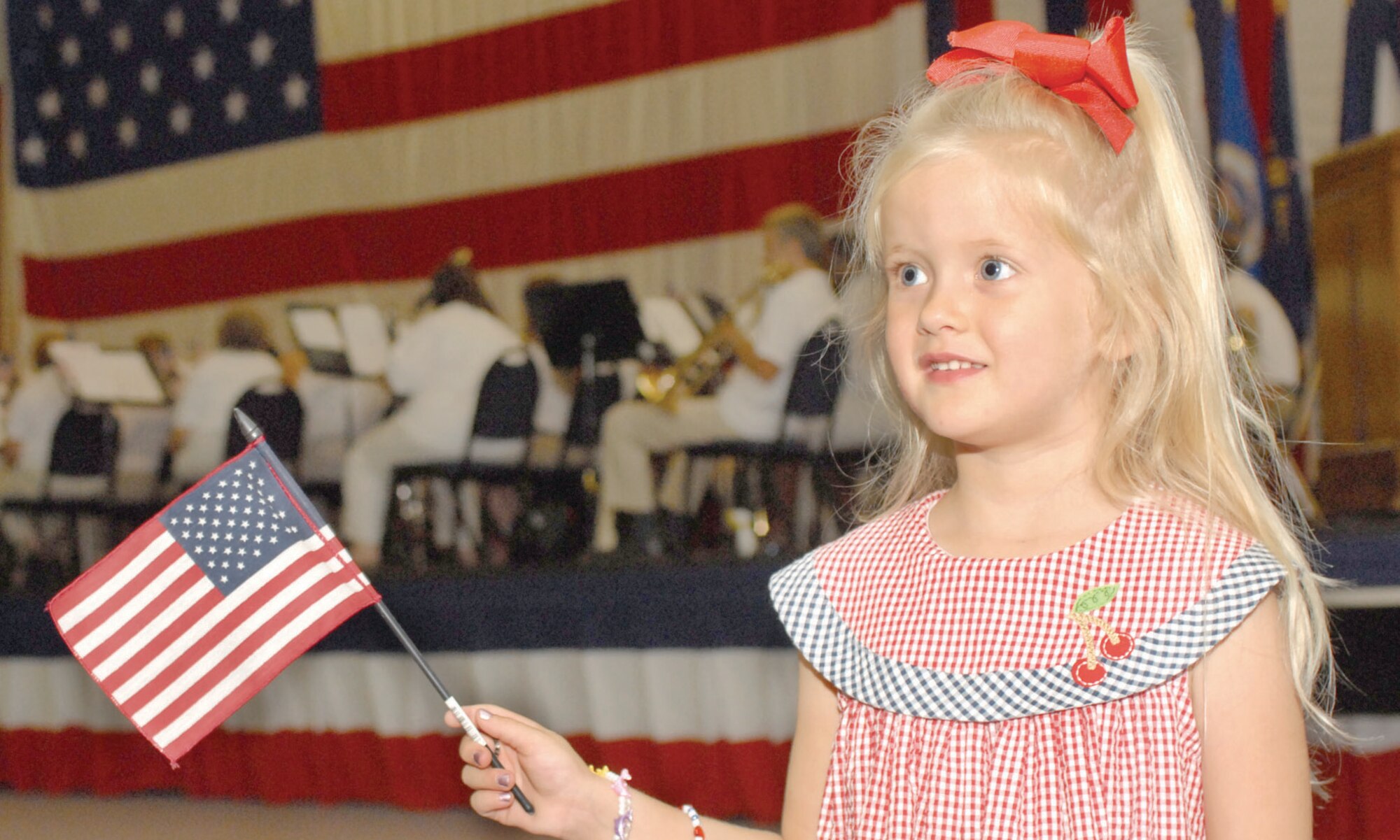 Lilah Hartman, 4, daughter of 1st Lt. Devin Hartman, 2d Aircraft Maintenance Squadron, and Krystal Hartman, swings her flag as she listens to the Shreveport Metropolitan Concert Band Sunday in Hoban Hall. The Barksdale Retiree Activities Office hosted the event.