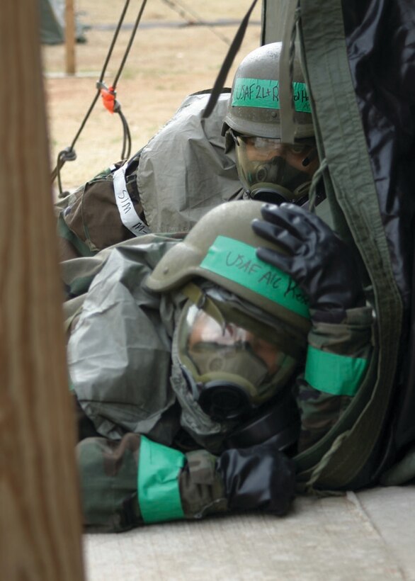 Two Airmen try to find cover after being caught in the open during a mortar attack March 28. With Airmen not knowing if the attack was a chemical attack or conventional mortars, everyone put on all their chemical protection gear until the “all clear” sounded. The 72nd Air Base Wing and the 552nd Air Control Wing teamed up for the first time as the 624th Air Expeditionary Wing to take part in War Wagon 06-03, an Operational Readiness Exercise designed to test both wings processes in a joint simulated deployed environment. See story page 12.